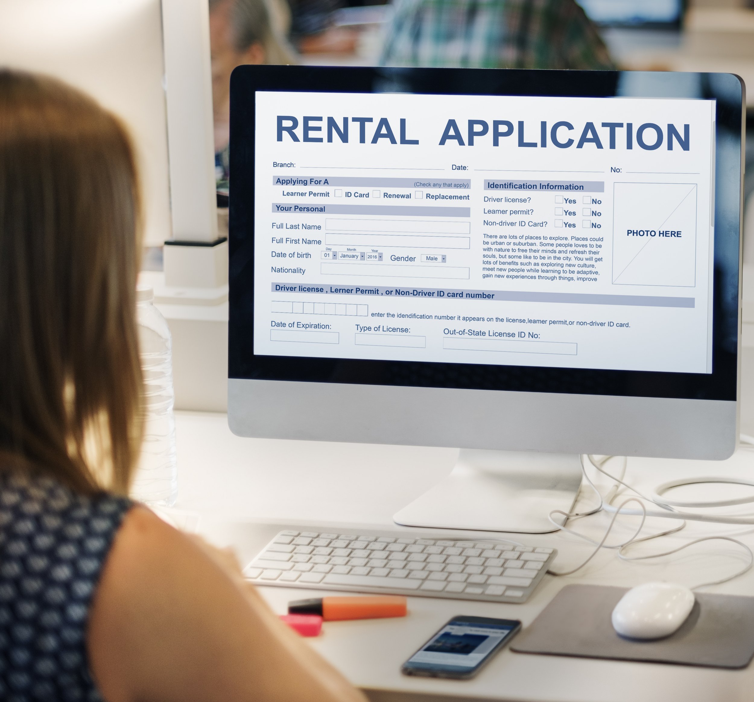 Woman sitting in front of computer screen with rental application.