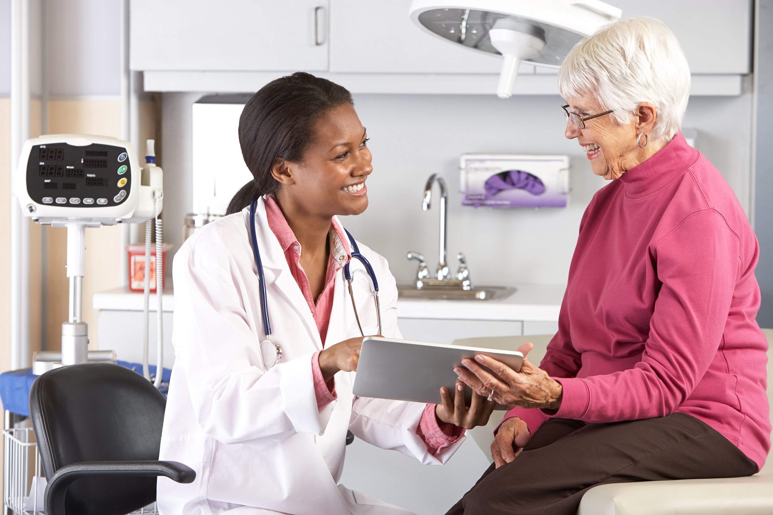 doctor discussing records with senior female patient