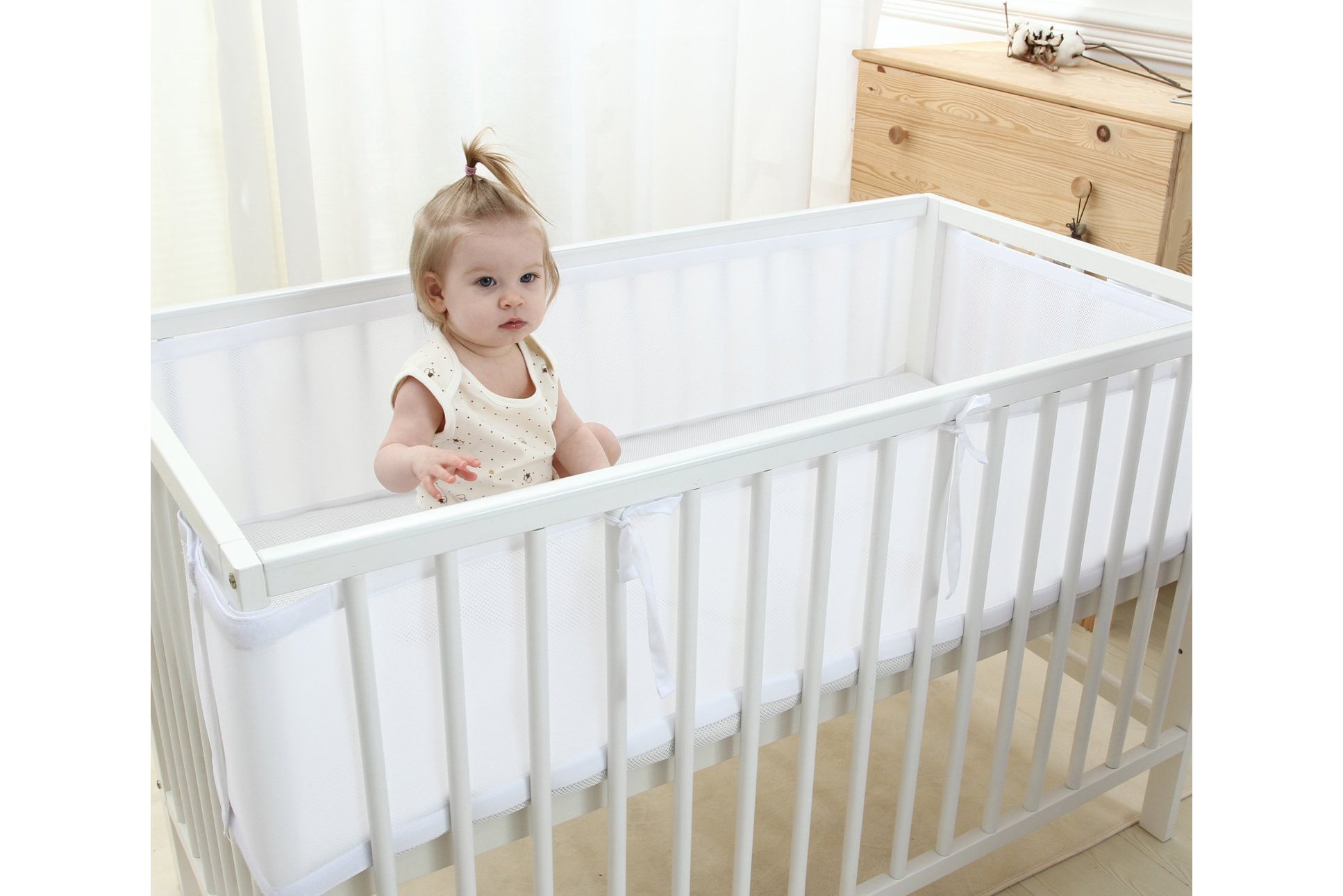 Baby in crib with bumpers