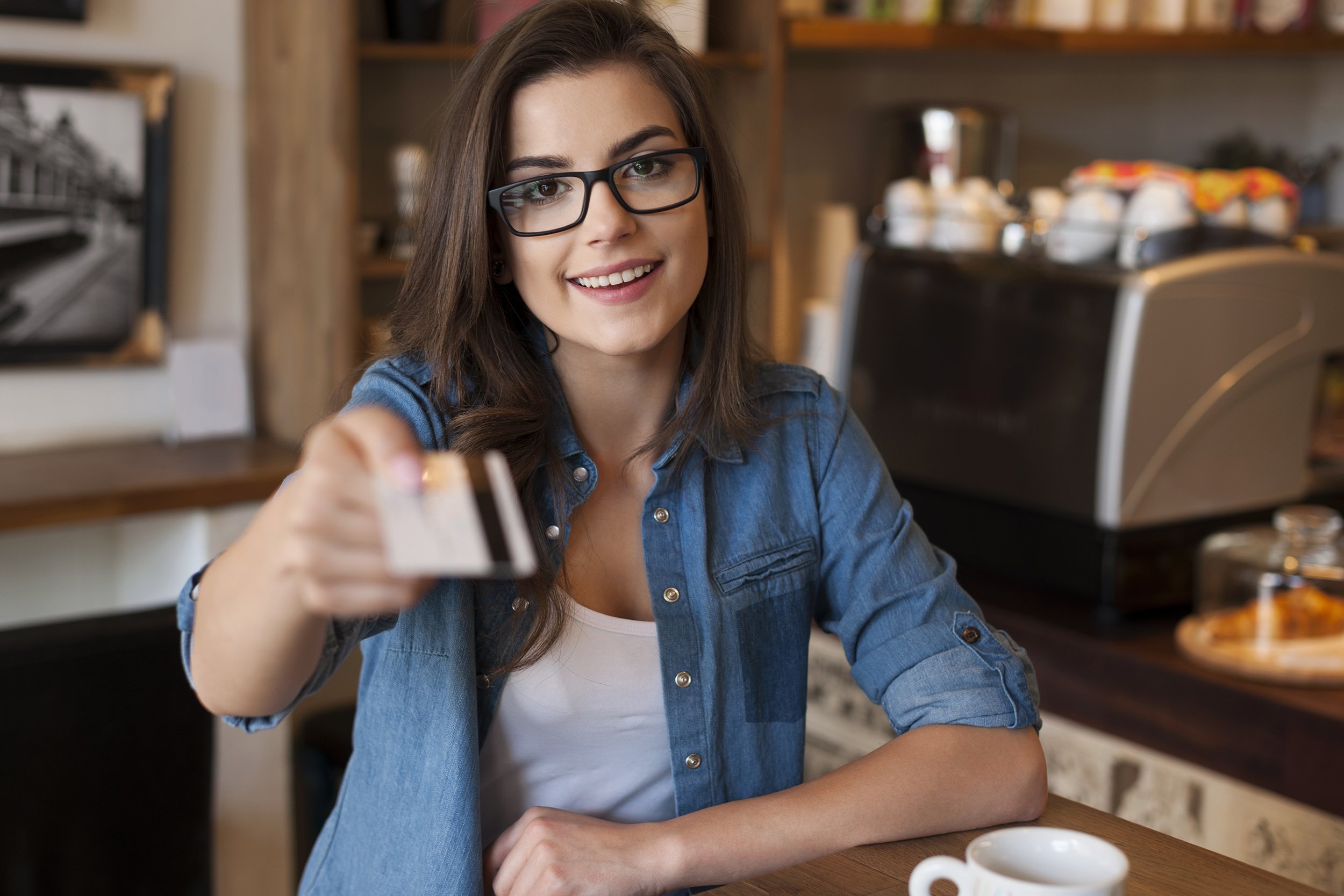 smiling woman paying for coffee by credit card