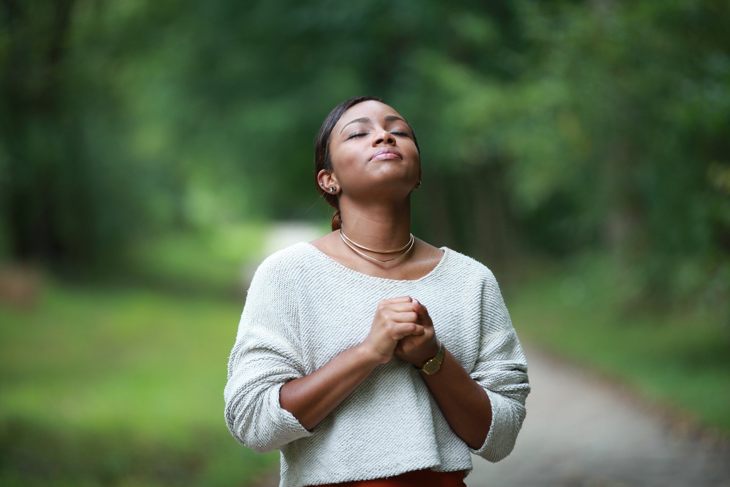 African American woman praying outside