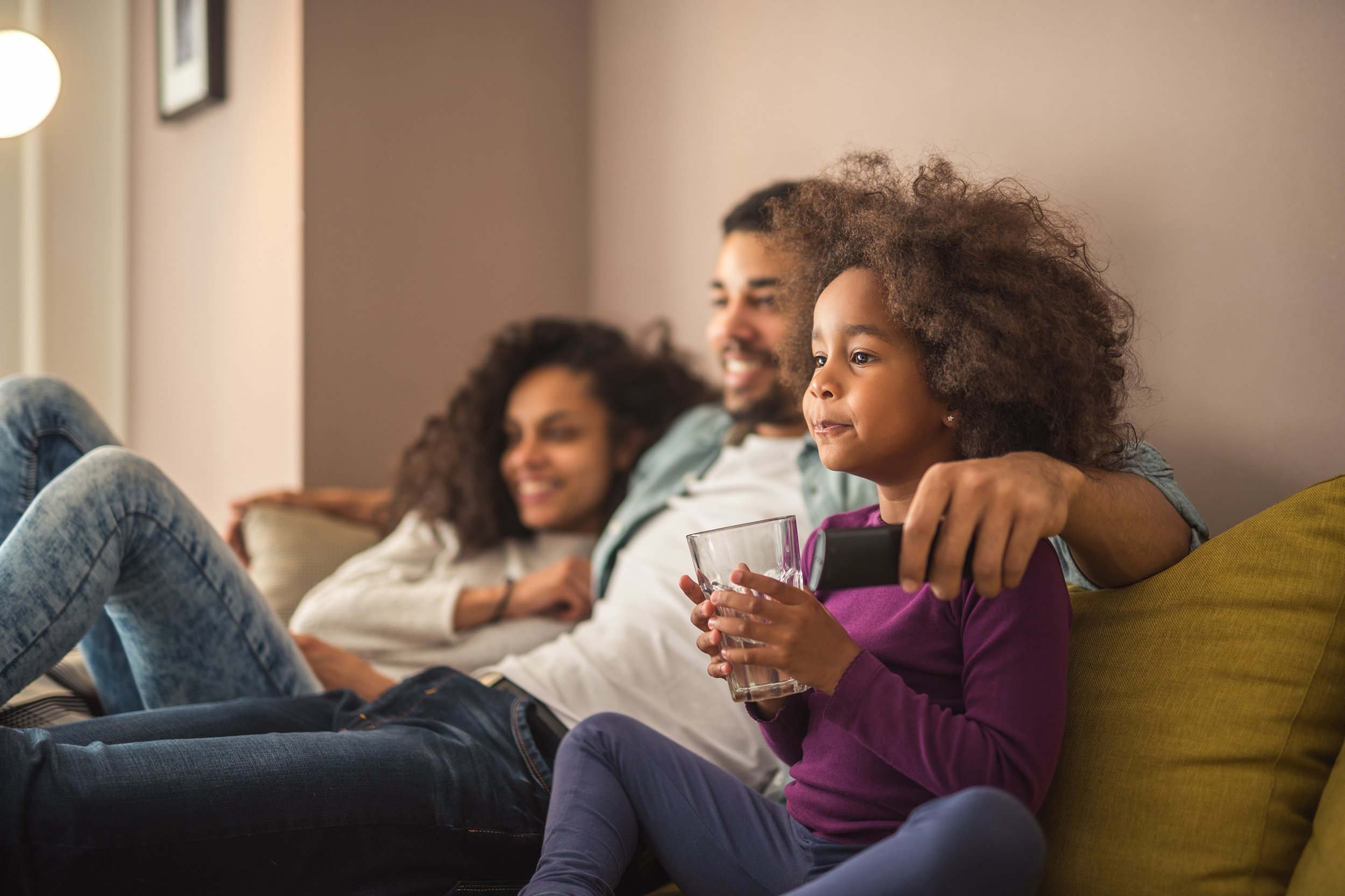 happy African American family relaxing on couch and watching TV