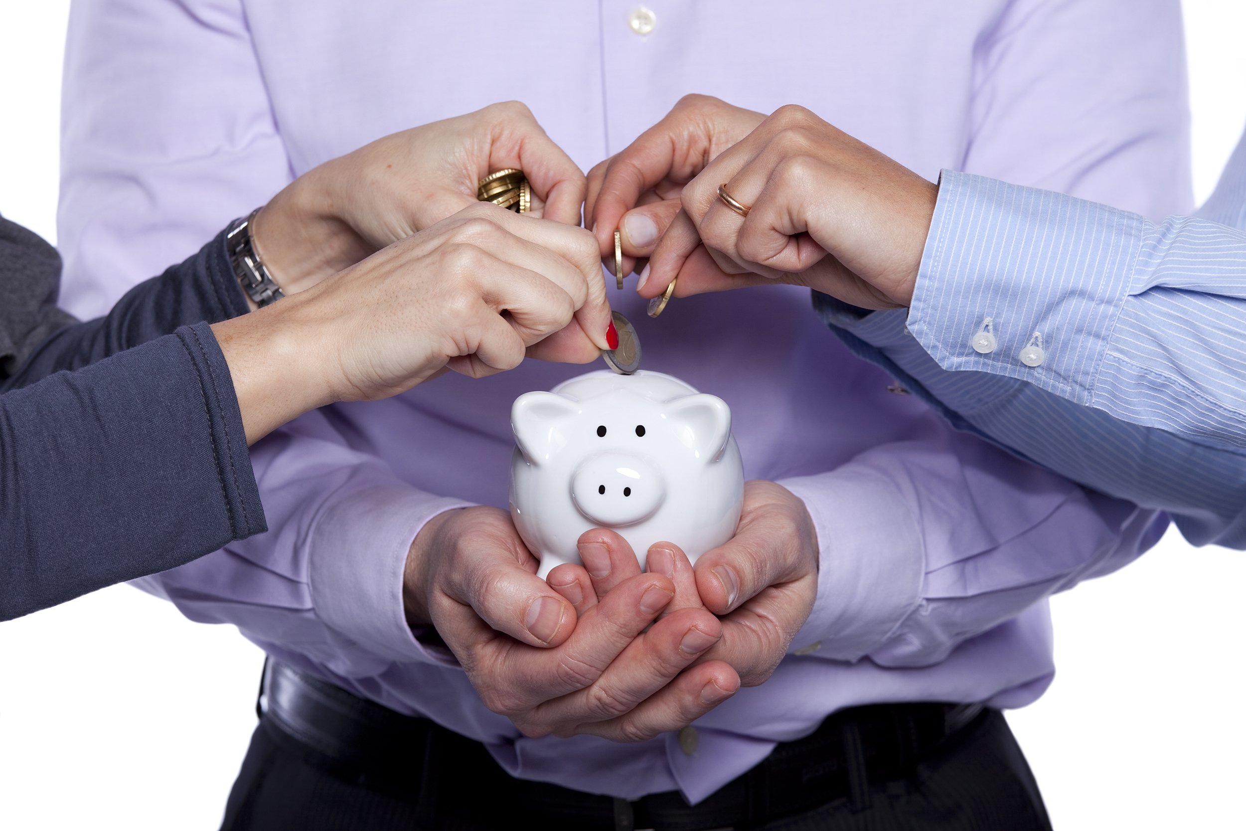 Group of business people putting money in a piggy bank