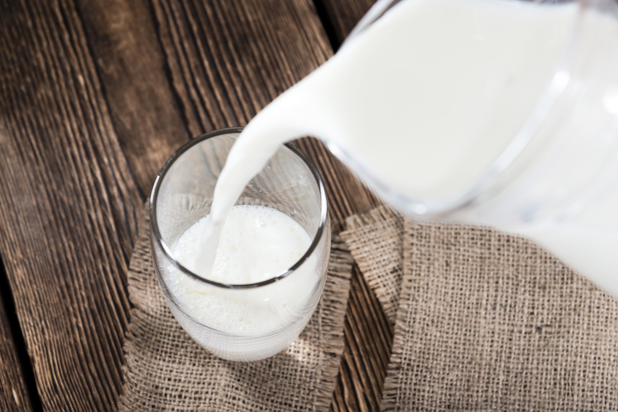 portion of milk on a dark wooden background