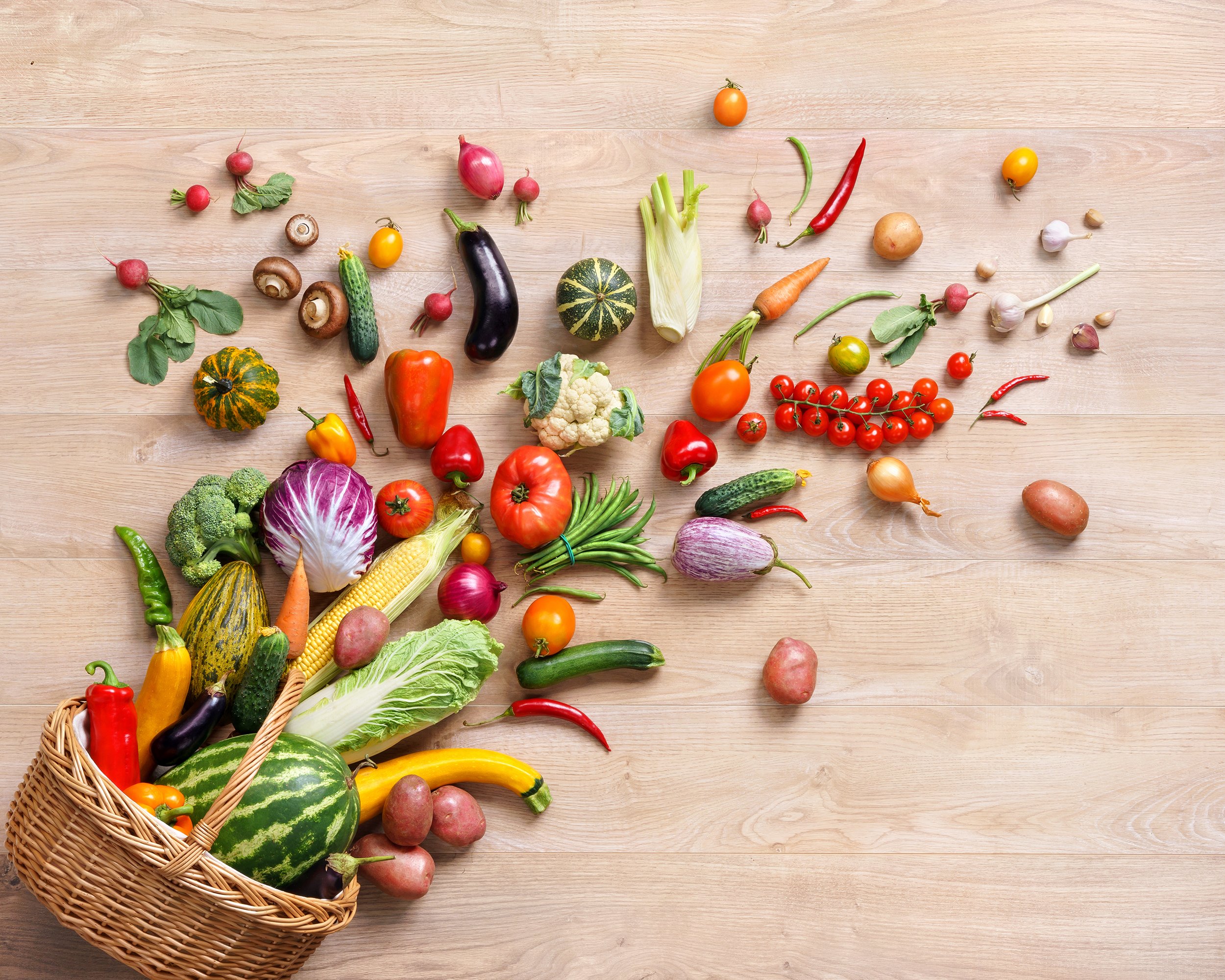 fruits and vegetables split from basket on wooden table