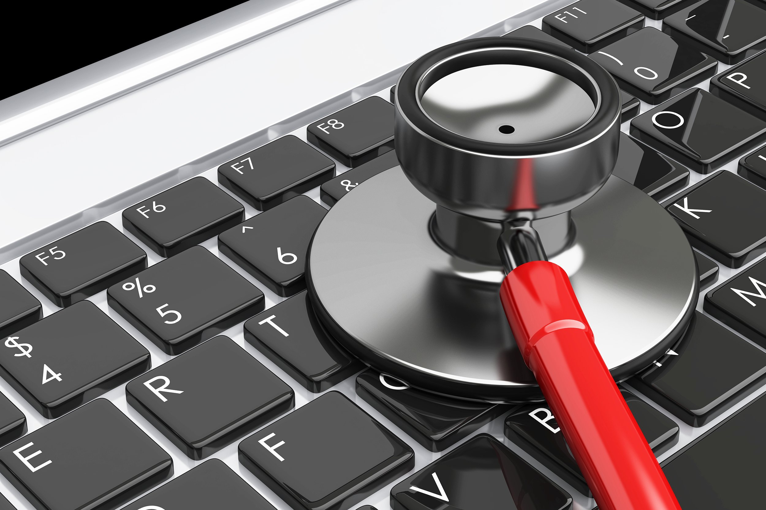 stethoscope lying on laptop keyboard