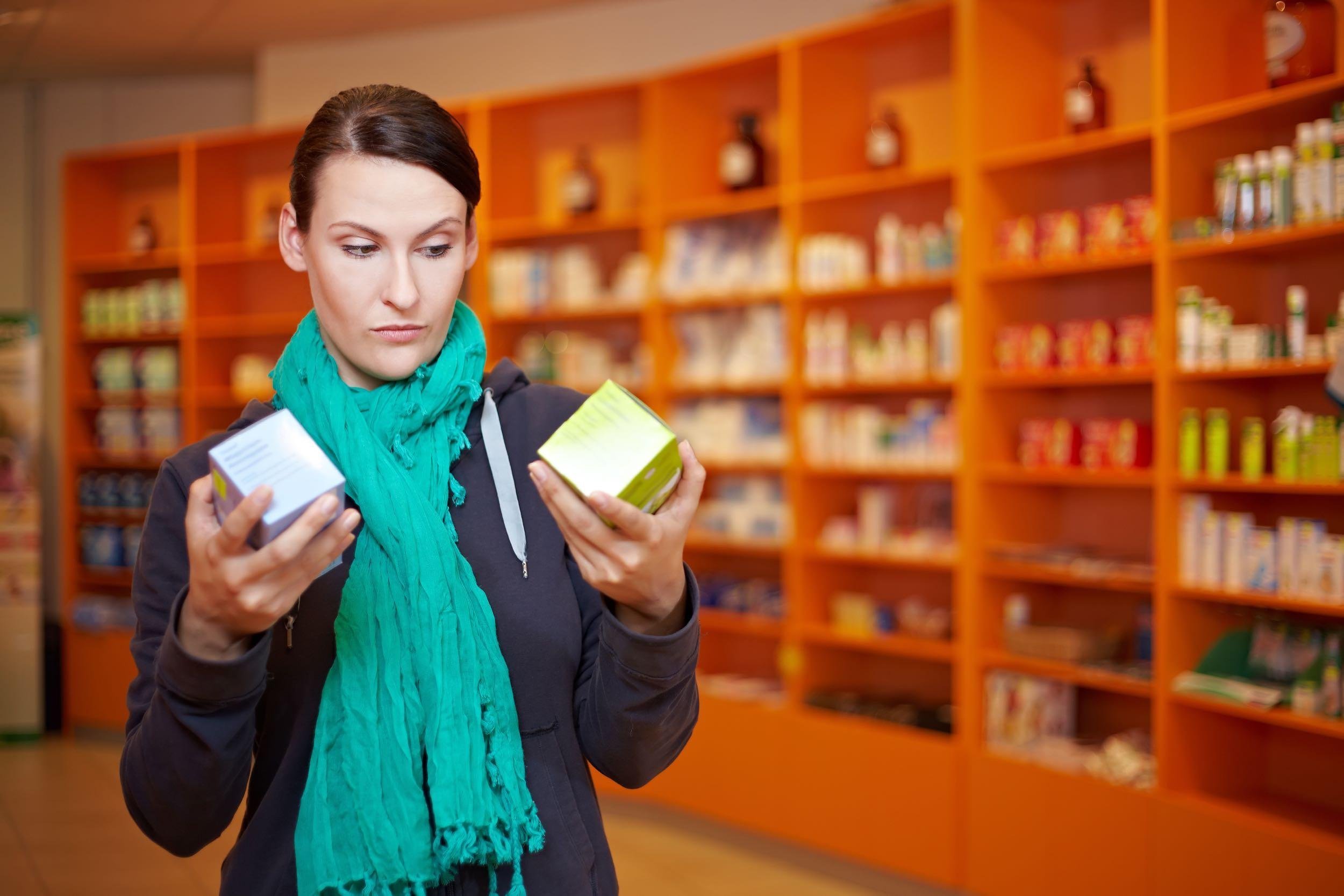 woman comparing prices of two medicines in store