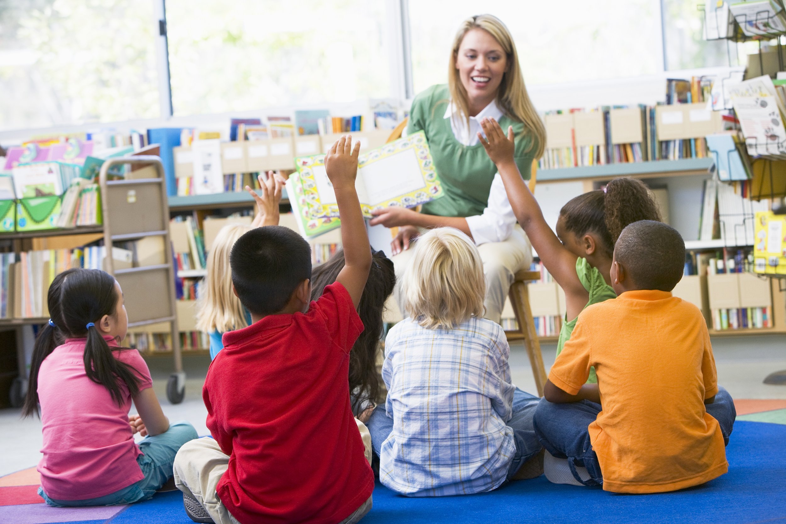 teacher teaching students with book