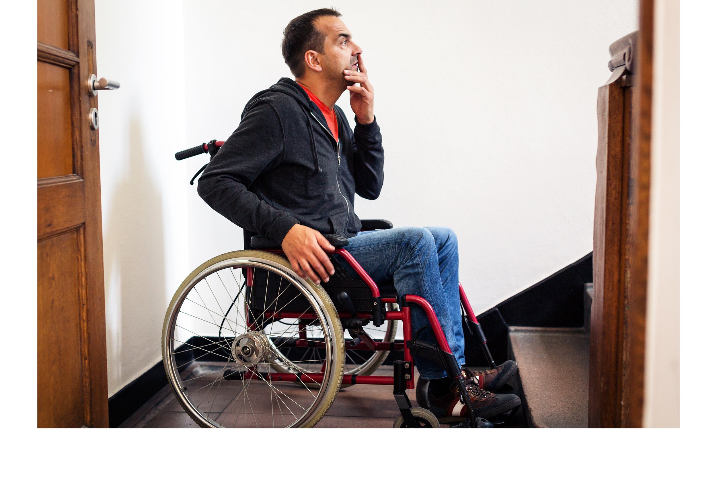 Man in a wheelchair unable to go up the stairs