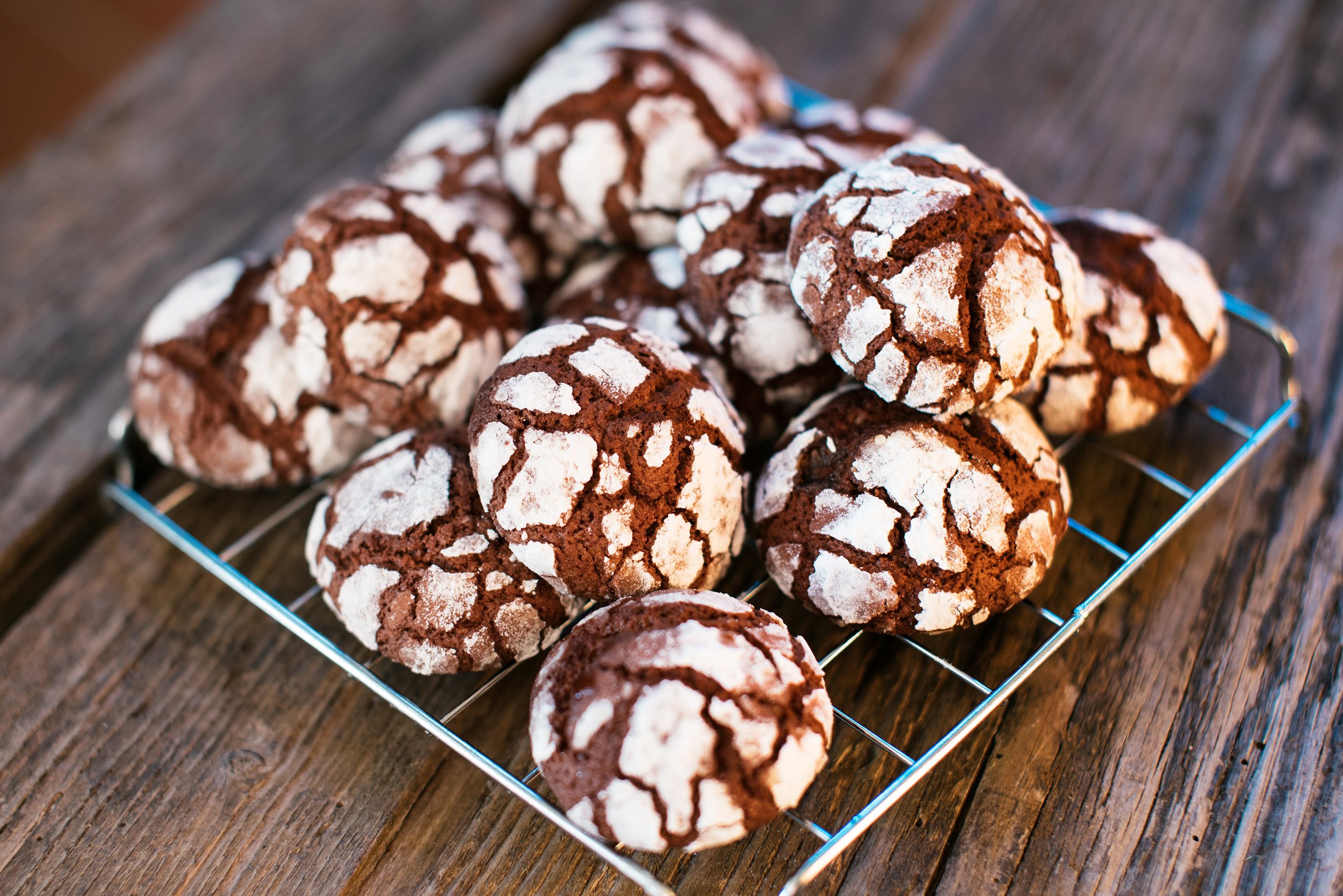 Chocolate crinkle cookies on a plate on a wooden table