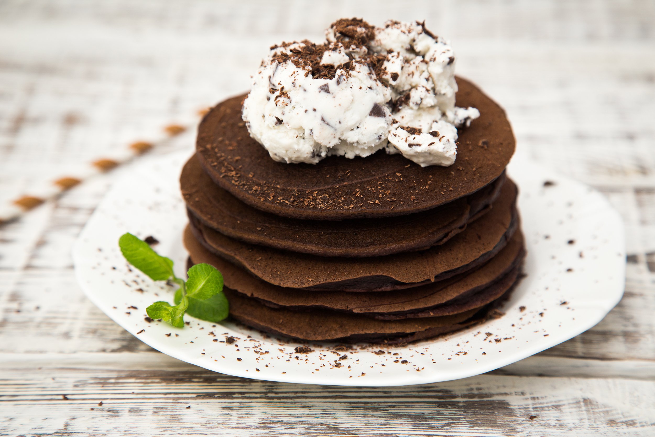 Stack of chocolate pancakes with cream on top