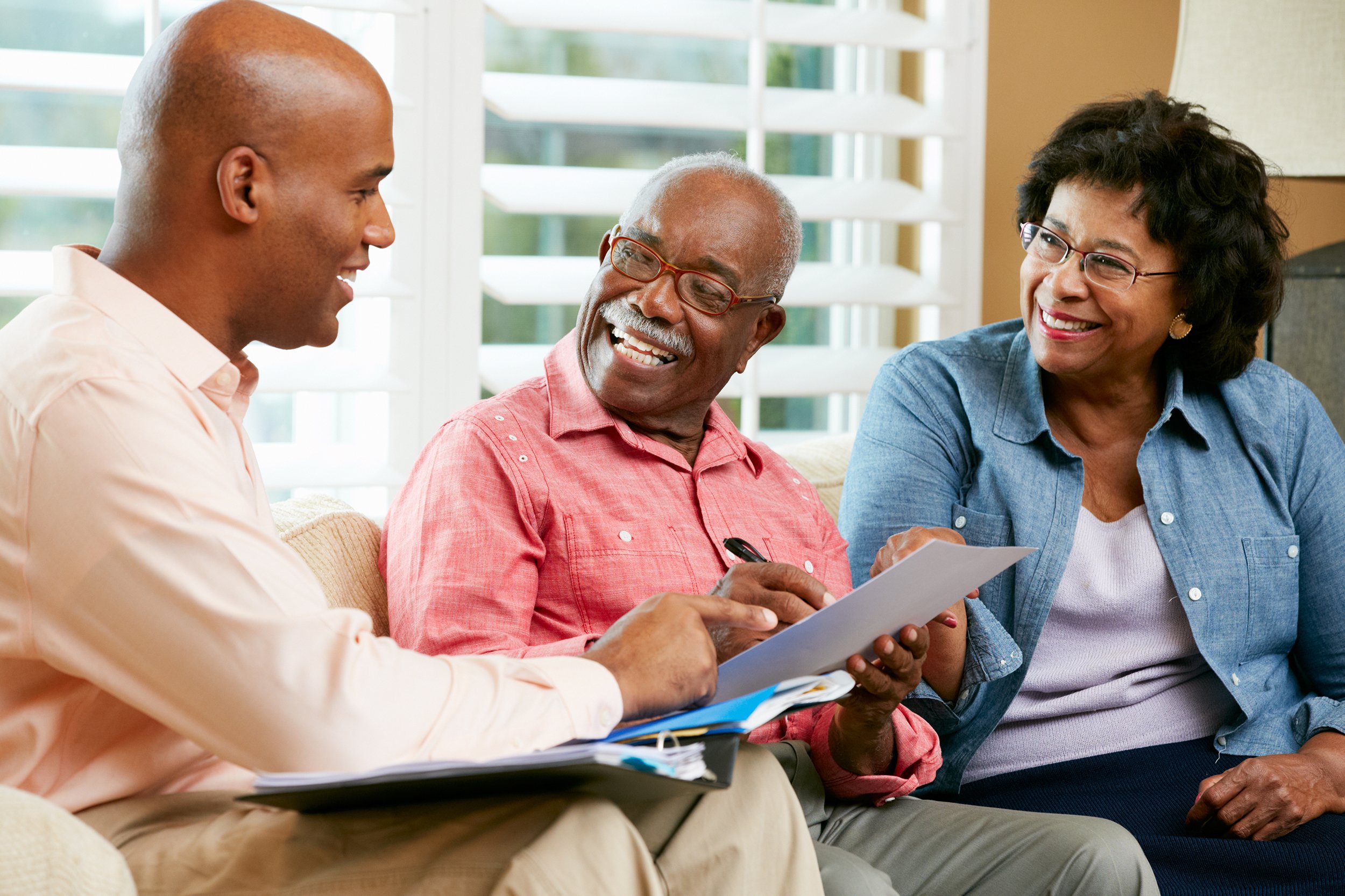 Senior couple meeting with a financial adviser at home