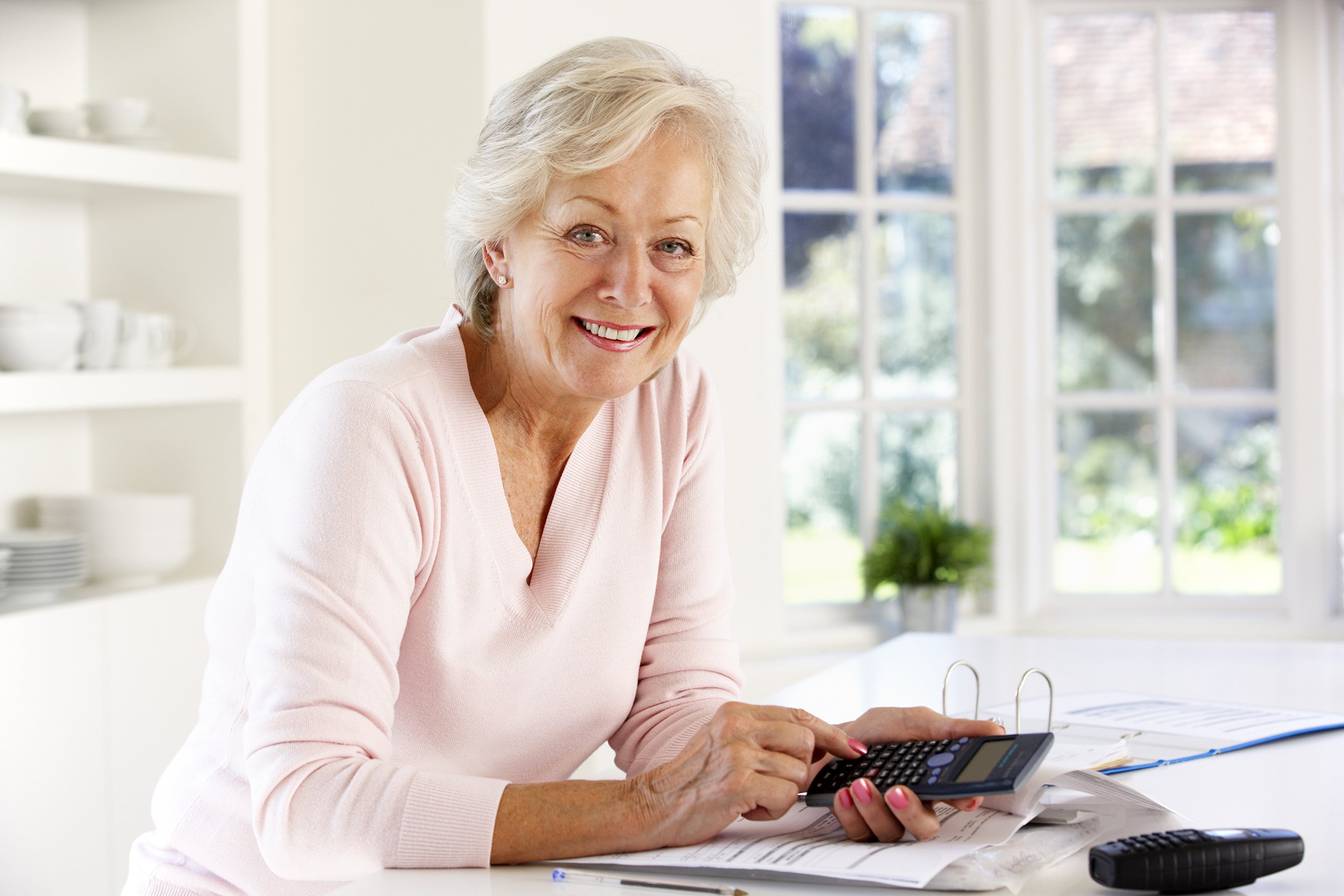 Retired woman handling bills at home