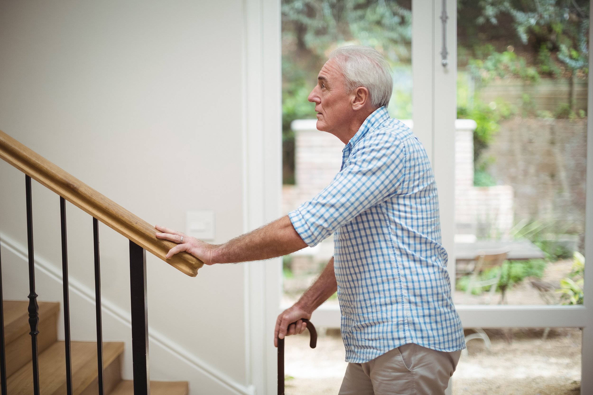 Senior man trying to climb up stairs at home