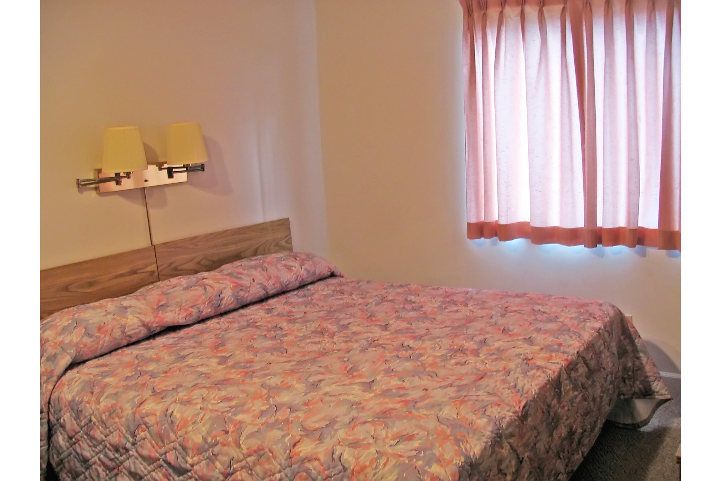 View of small, dark hotel room that is outdated