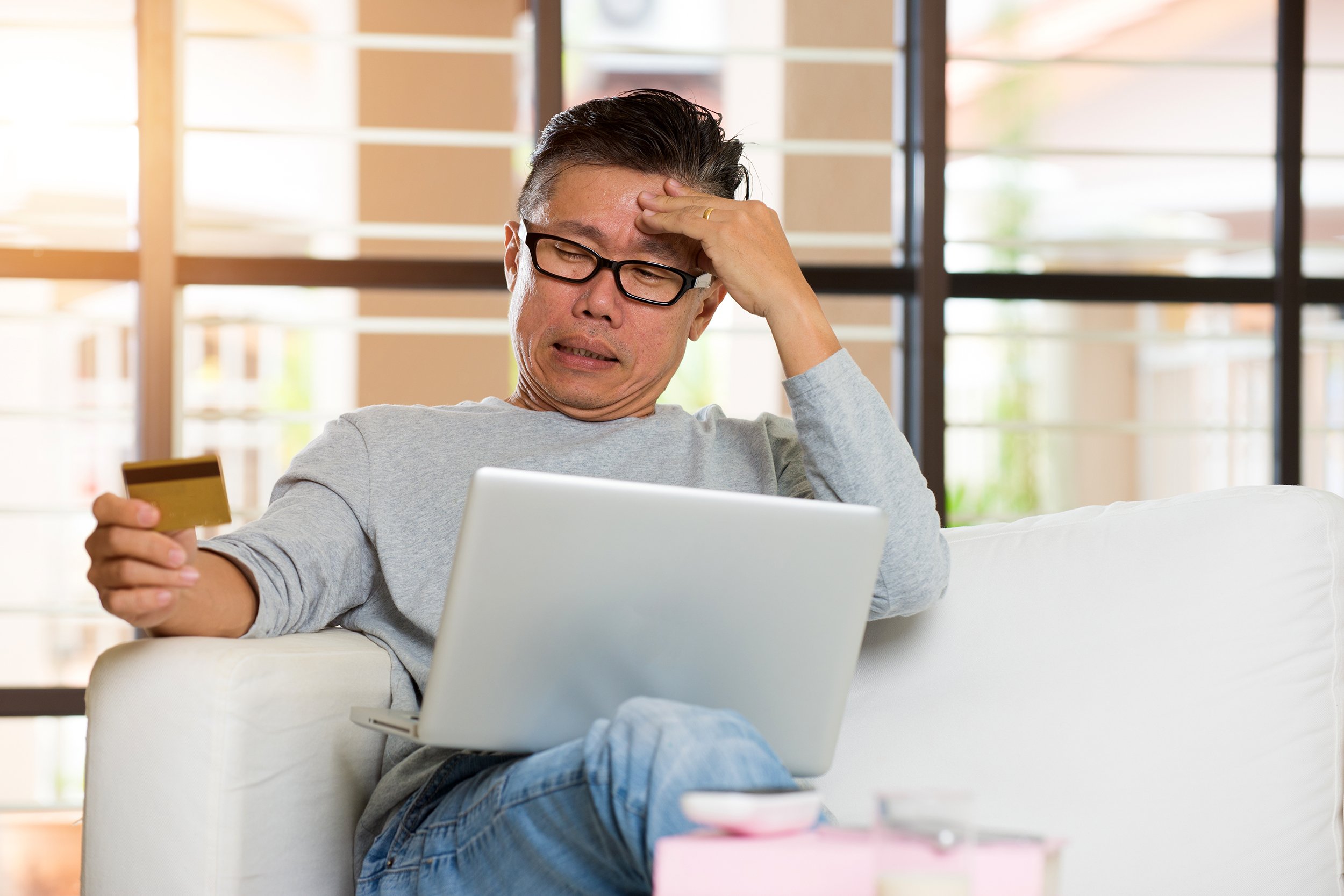 Tired Asian man paying online