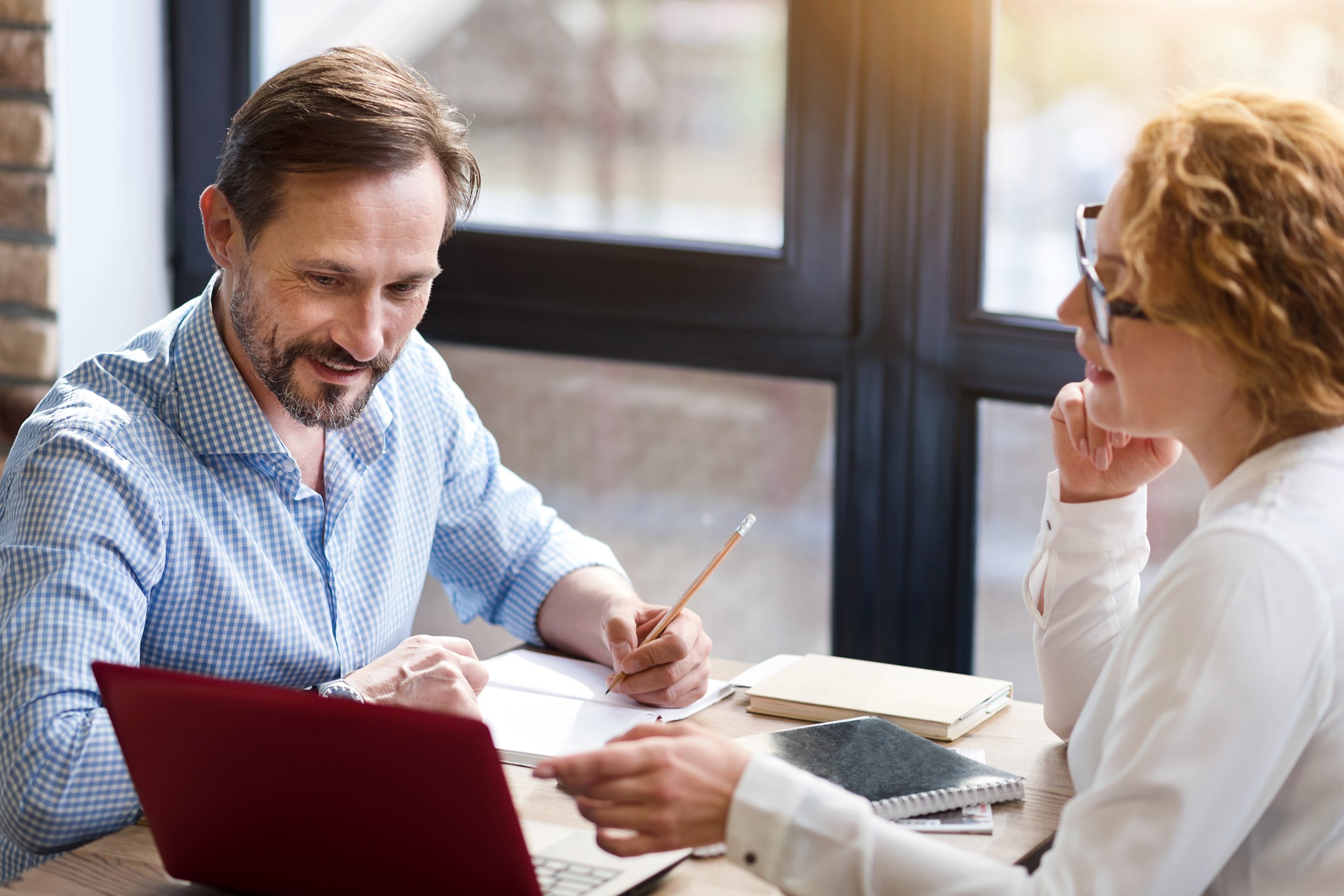 middle-aged couple working on laptop and taking notes