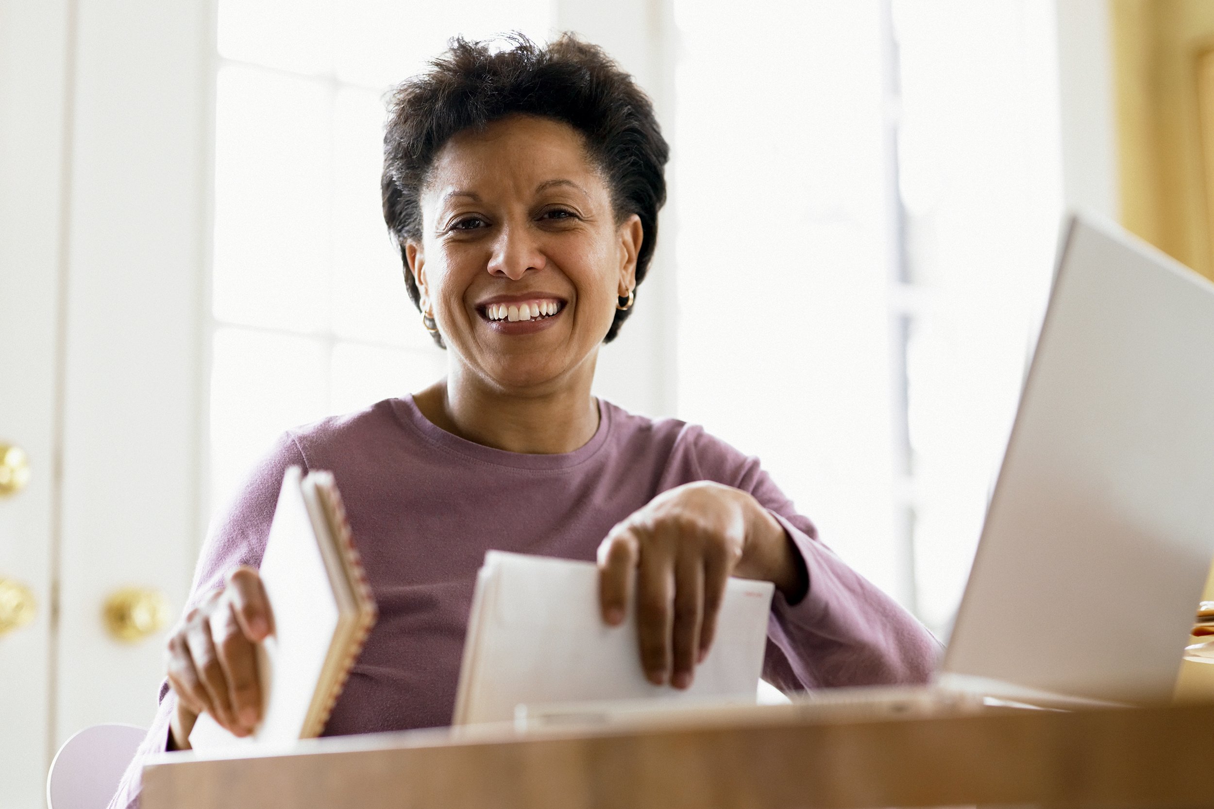 African American middle-aged woman smiling for the camera at her desk