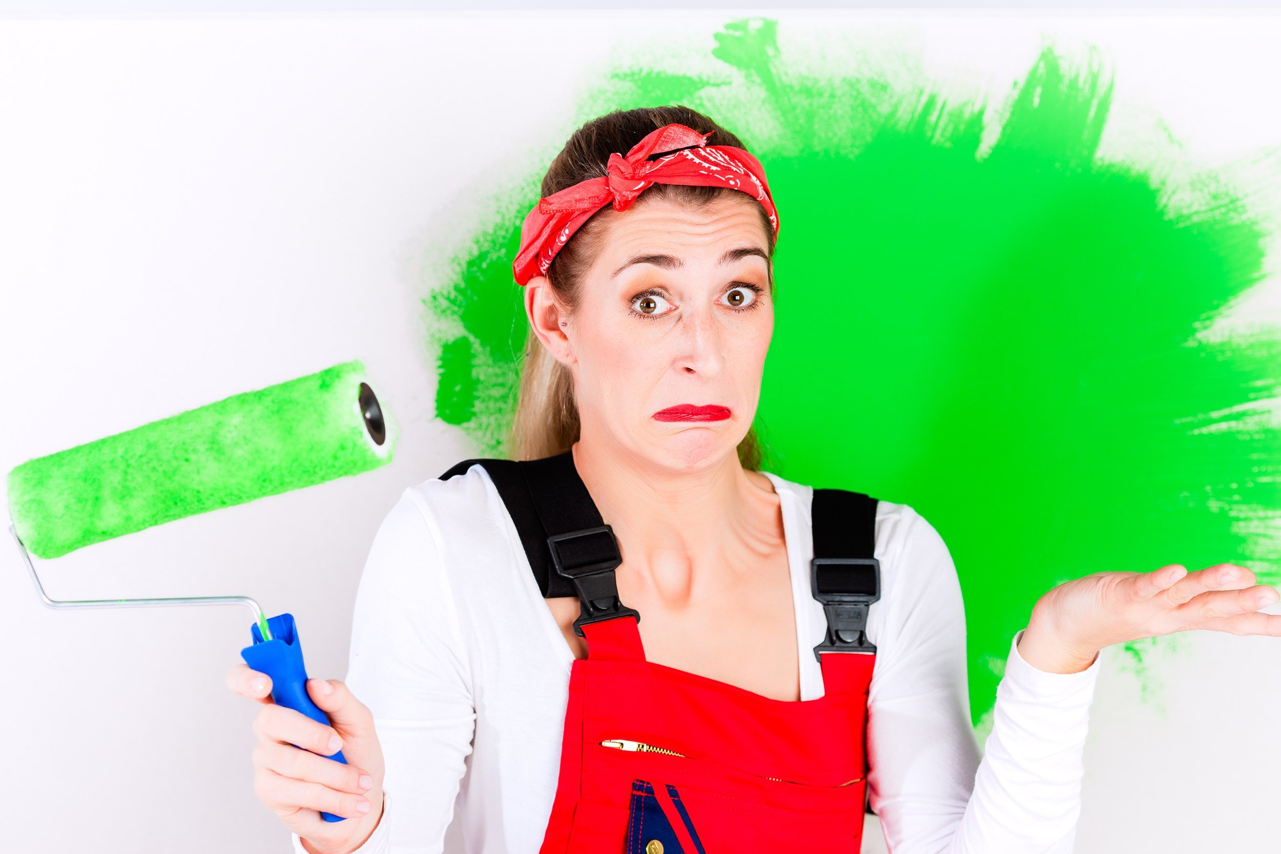 woman at home giving up painting wall with wrong color