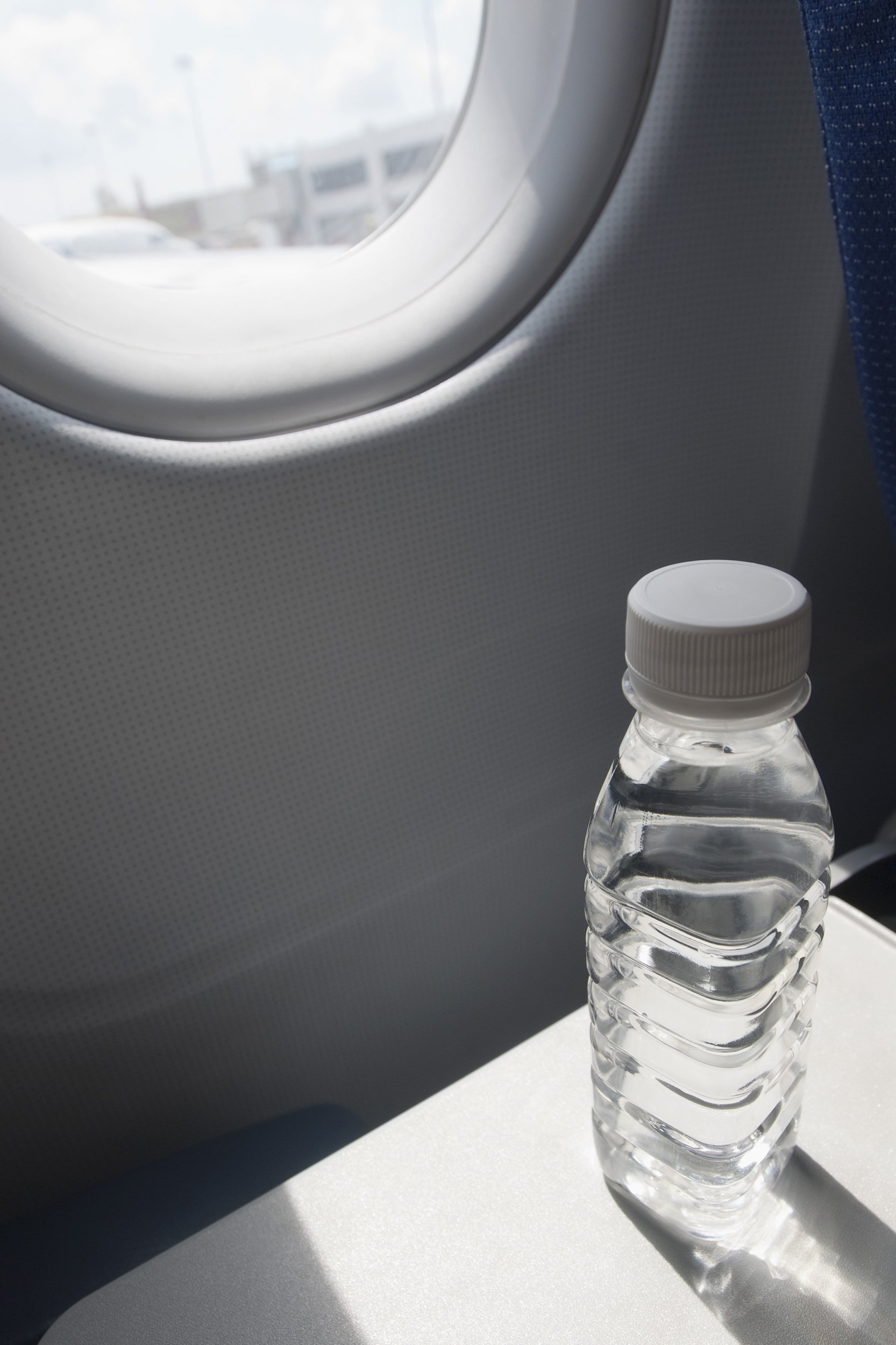water bottle on seat tray in an airplane