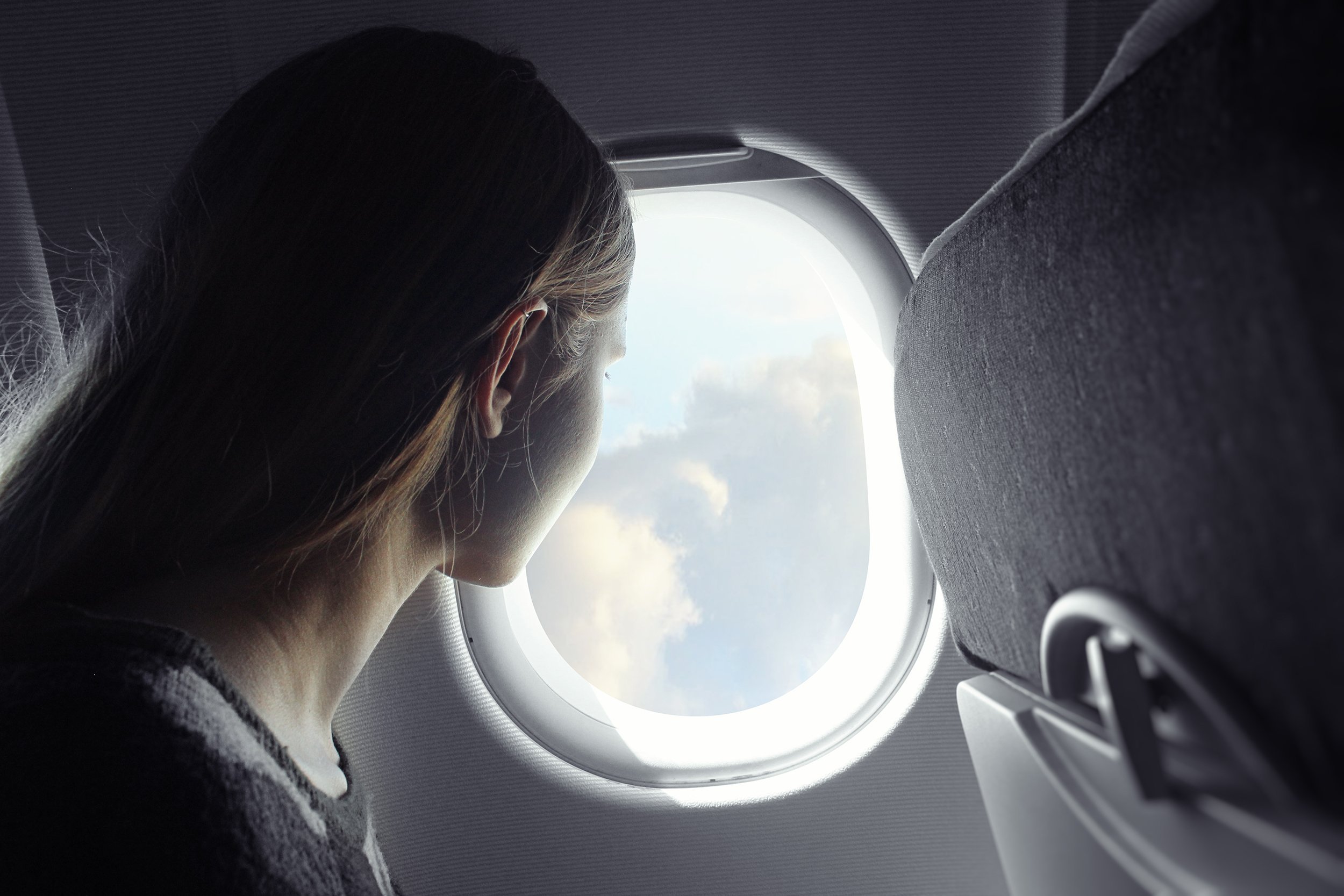 woman looking out of airplane window