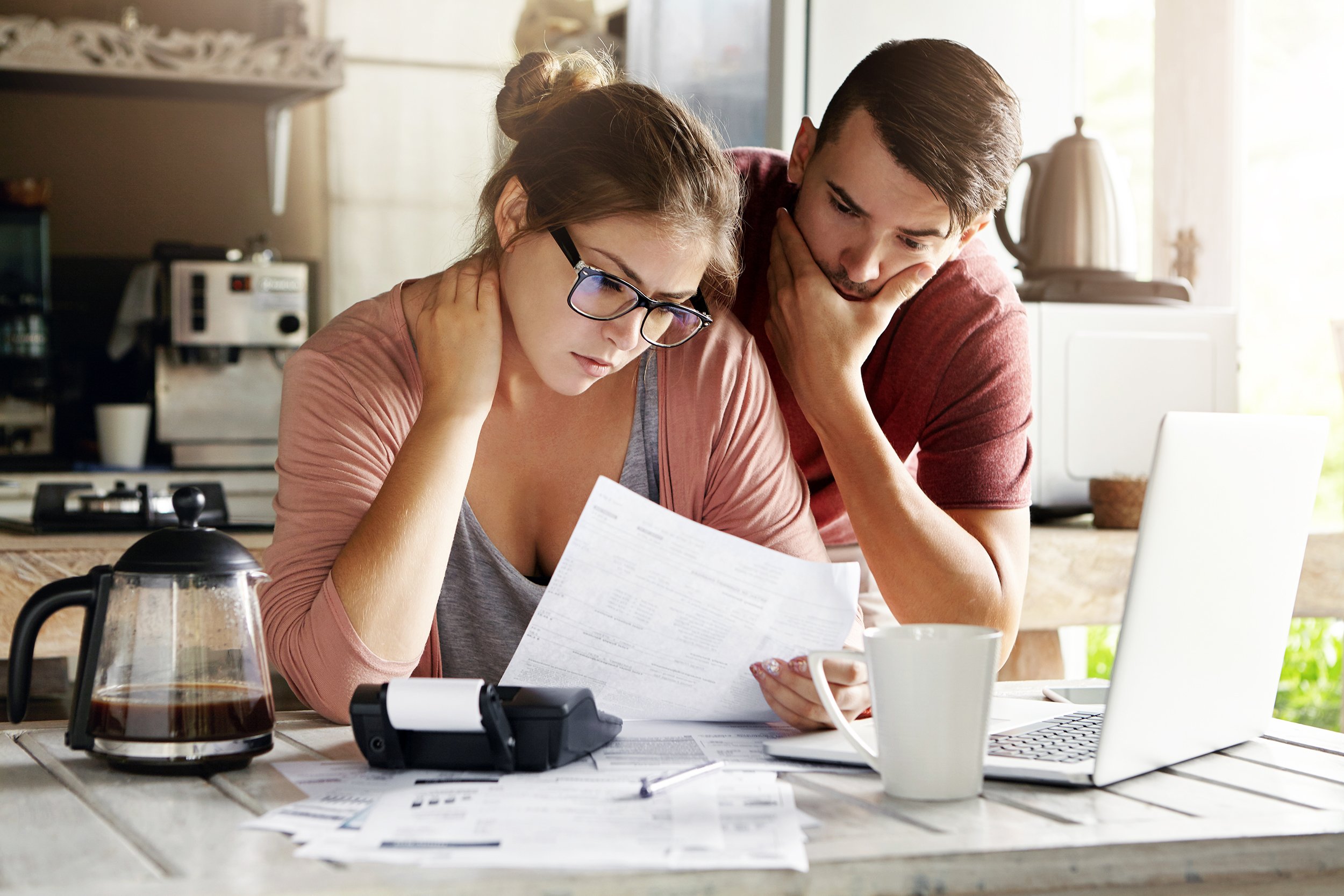 Young couple having money problems sitting at computer at home