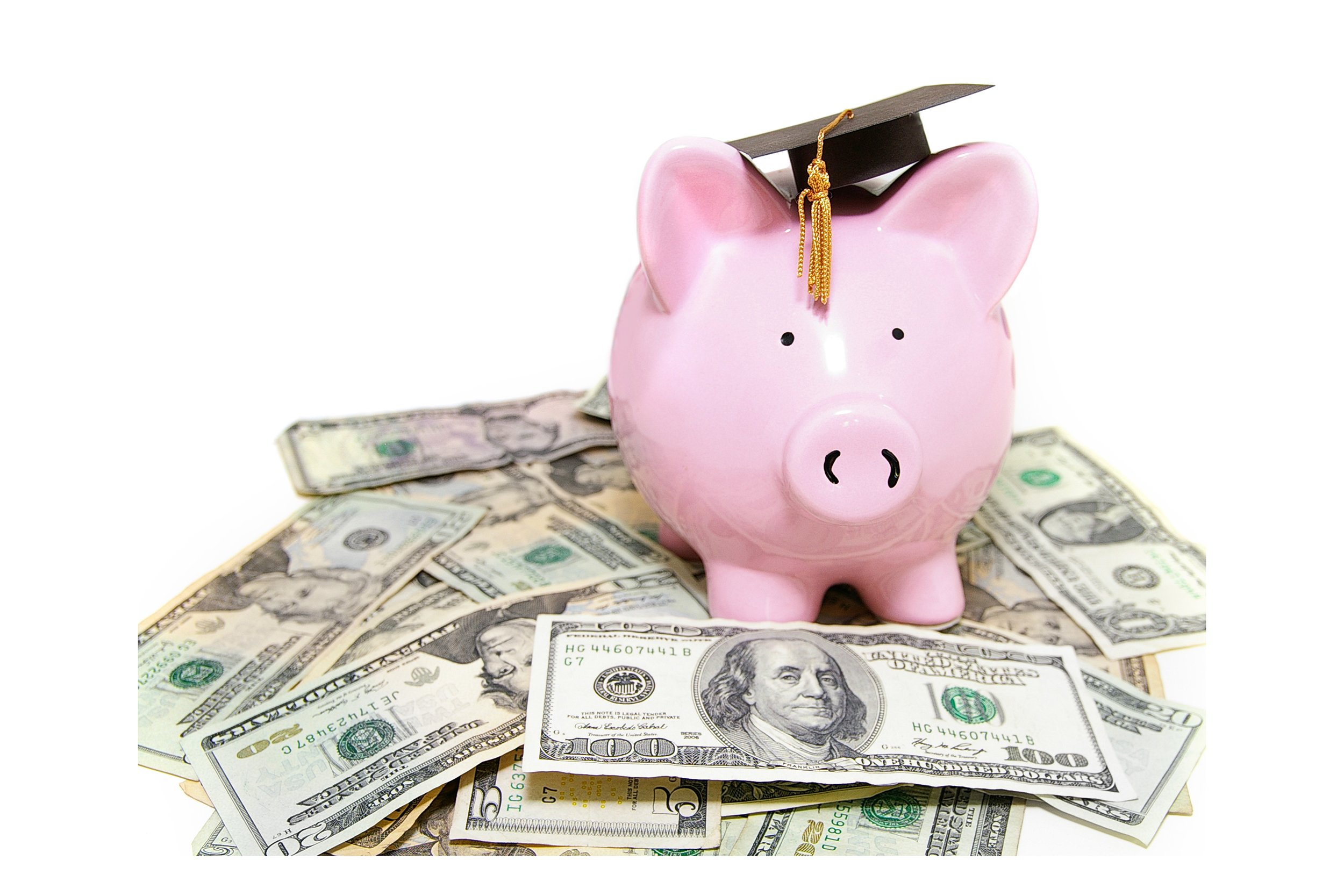 Piggy bank wearing a graduation cap on a pile of money
