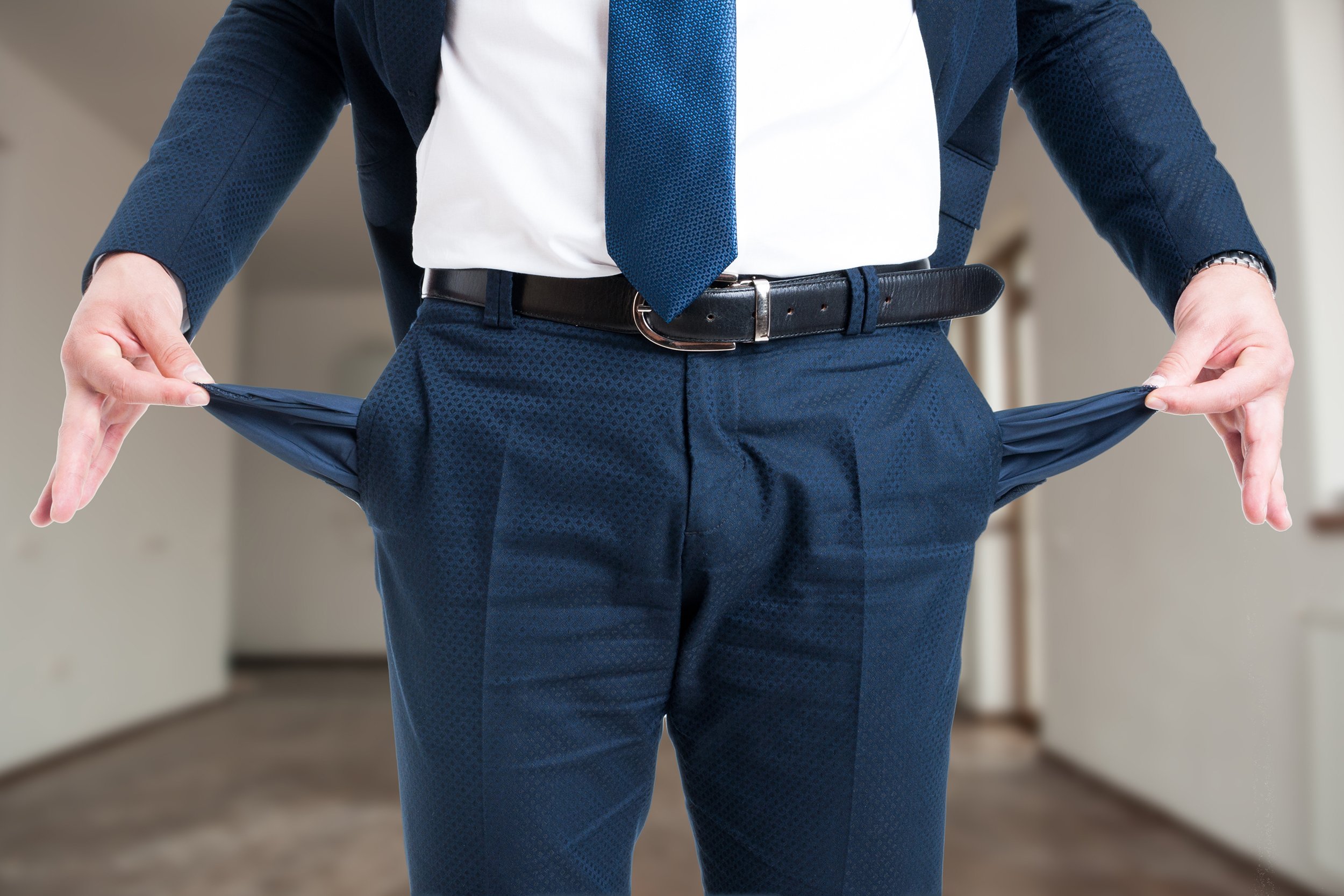Businessman holding out his empty pockets