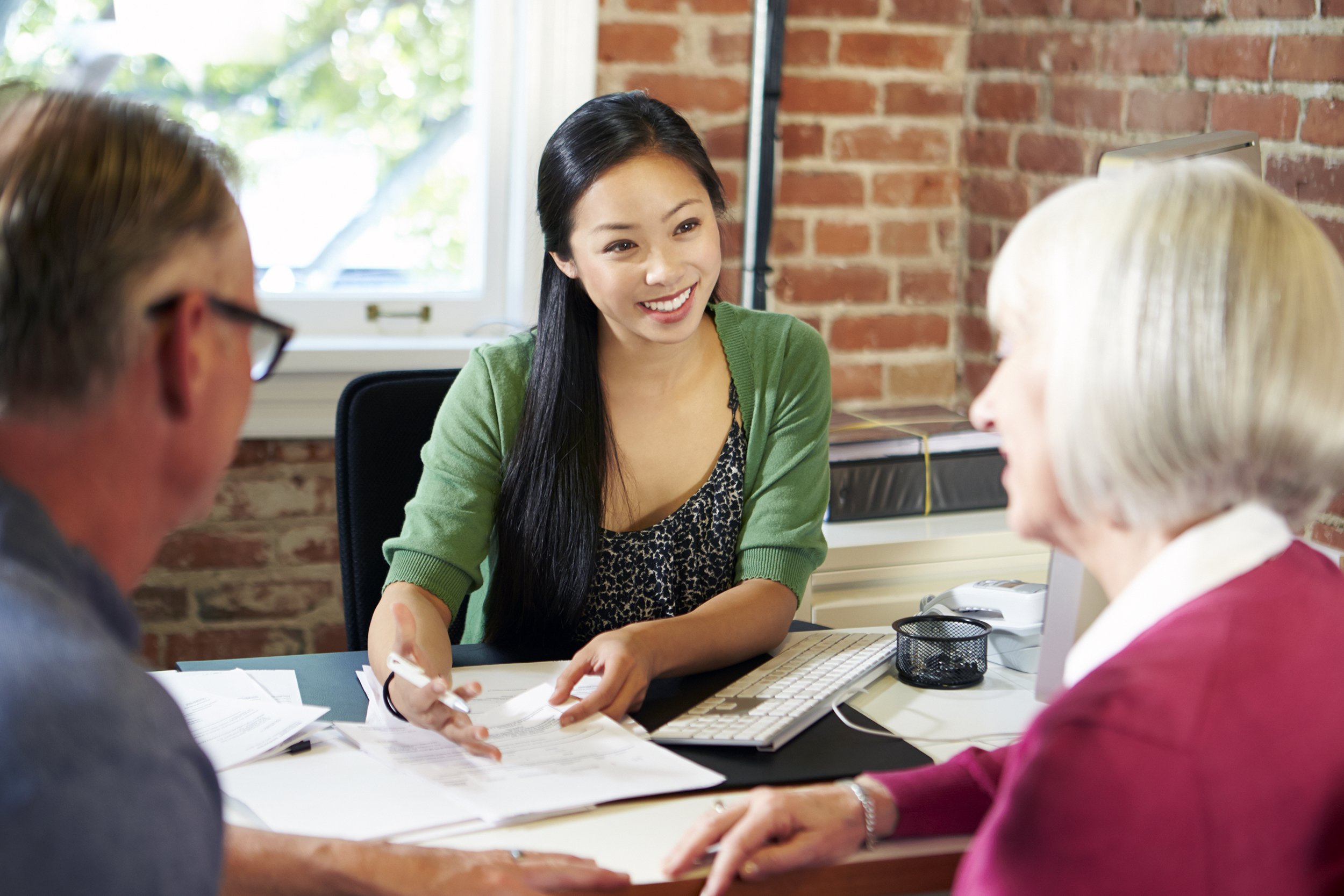 Senior couple meeting with a pleasant young financial advisor