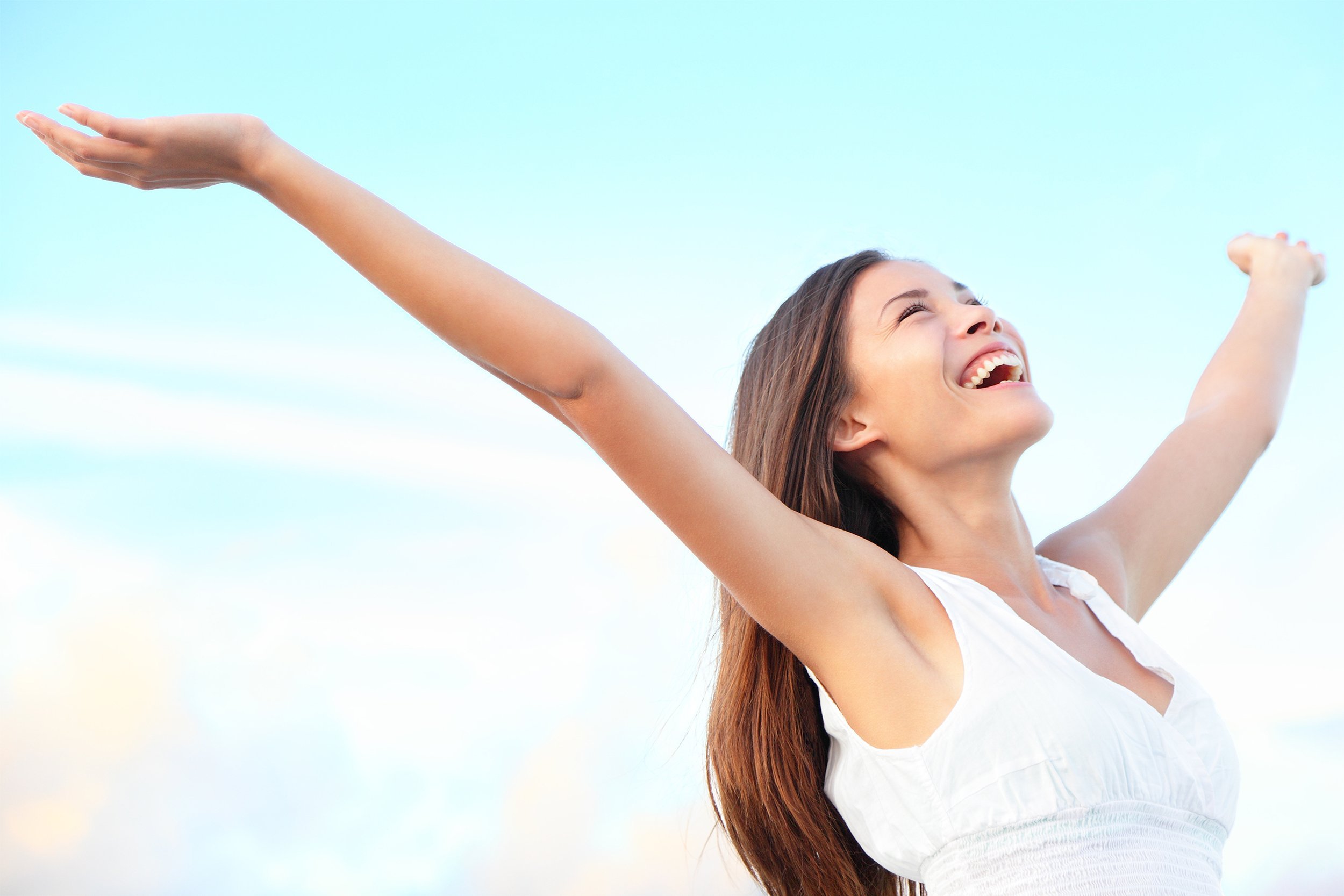 woman happy smiling joyful with arms up in the sun