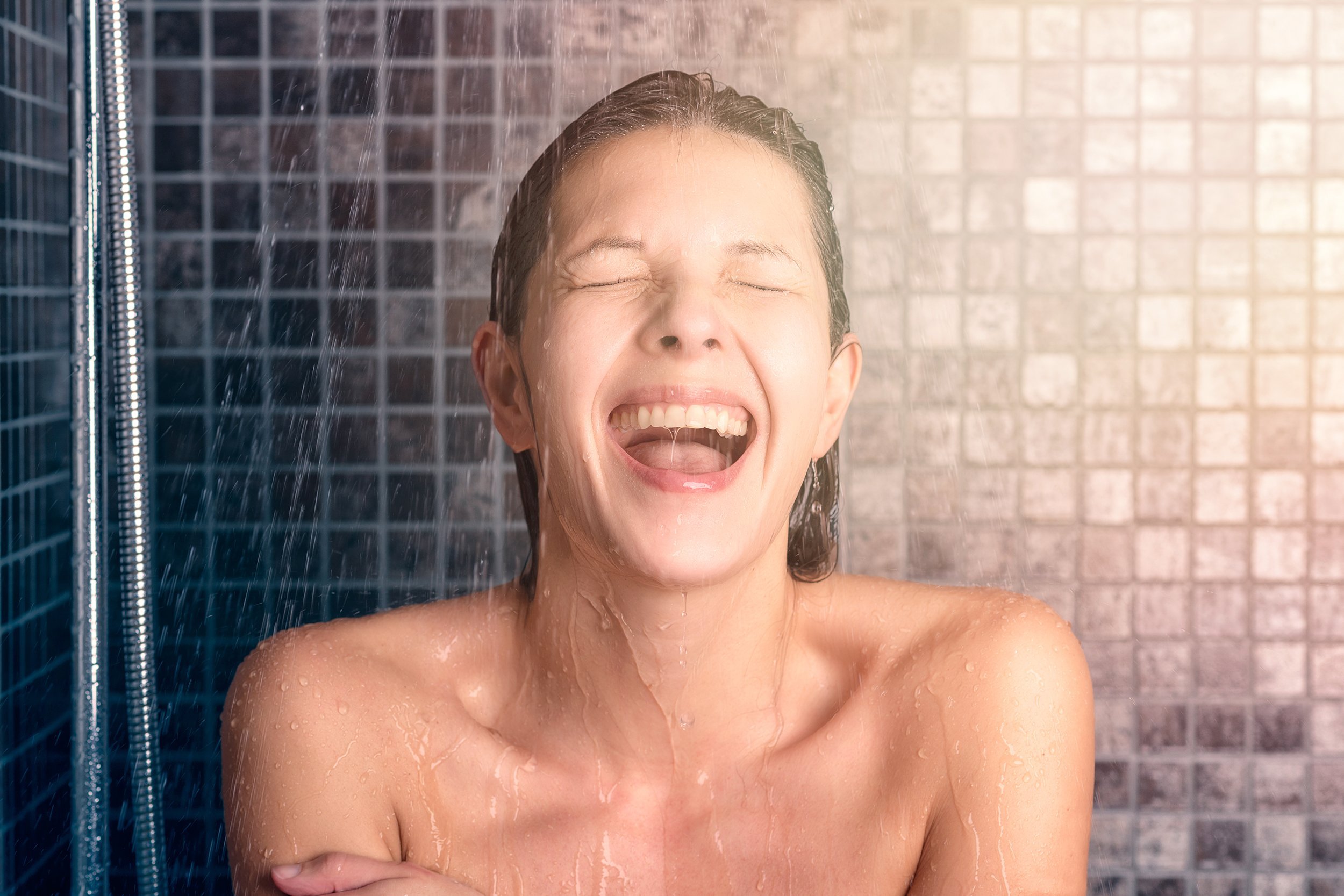 woman taking shower at the bathroom with mouth open and eyes closed