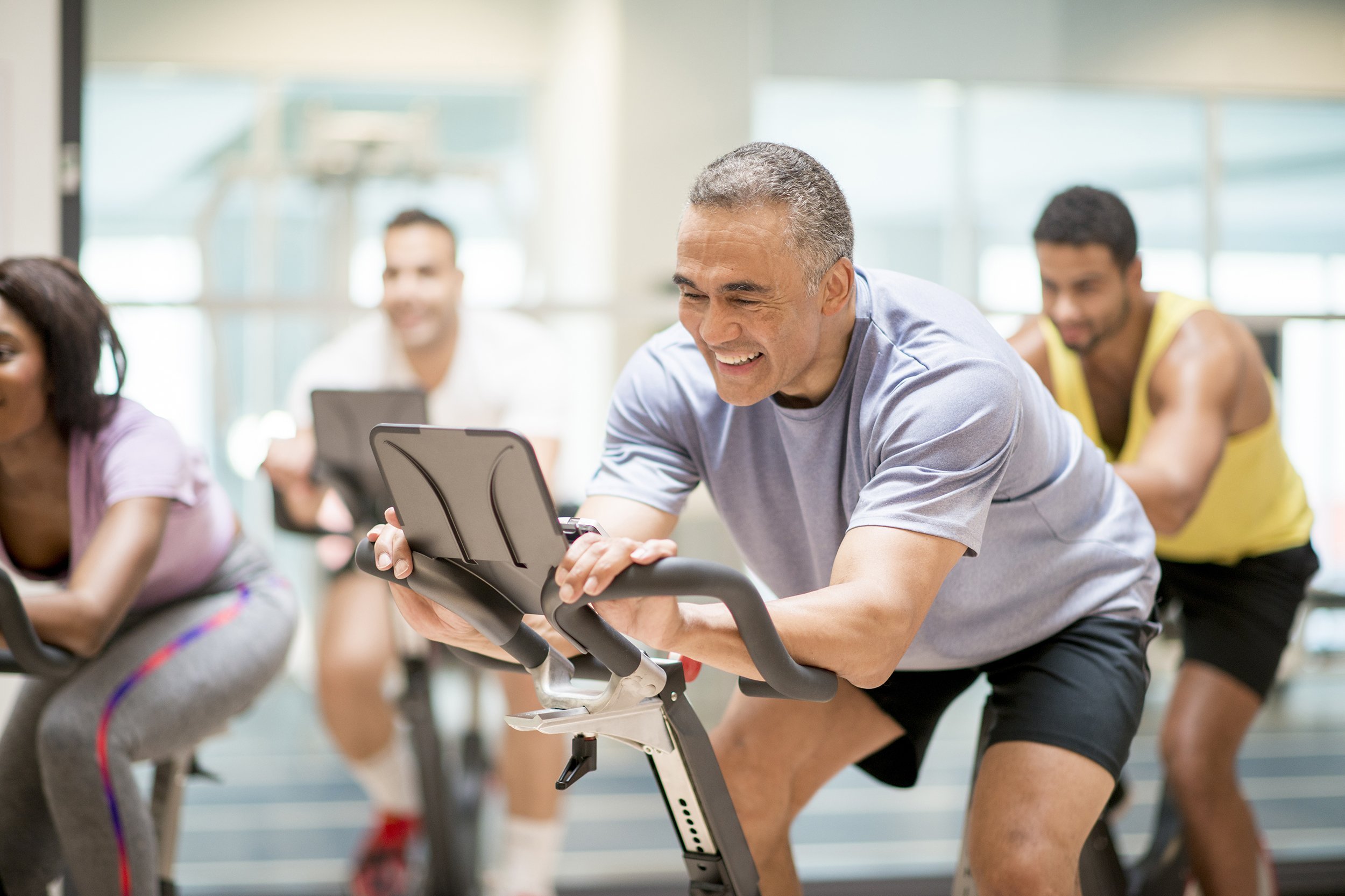 senior man in cycling class at the gym