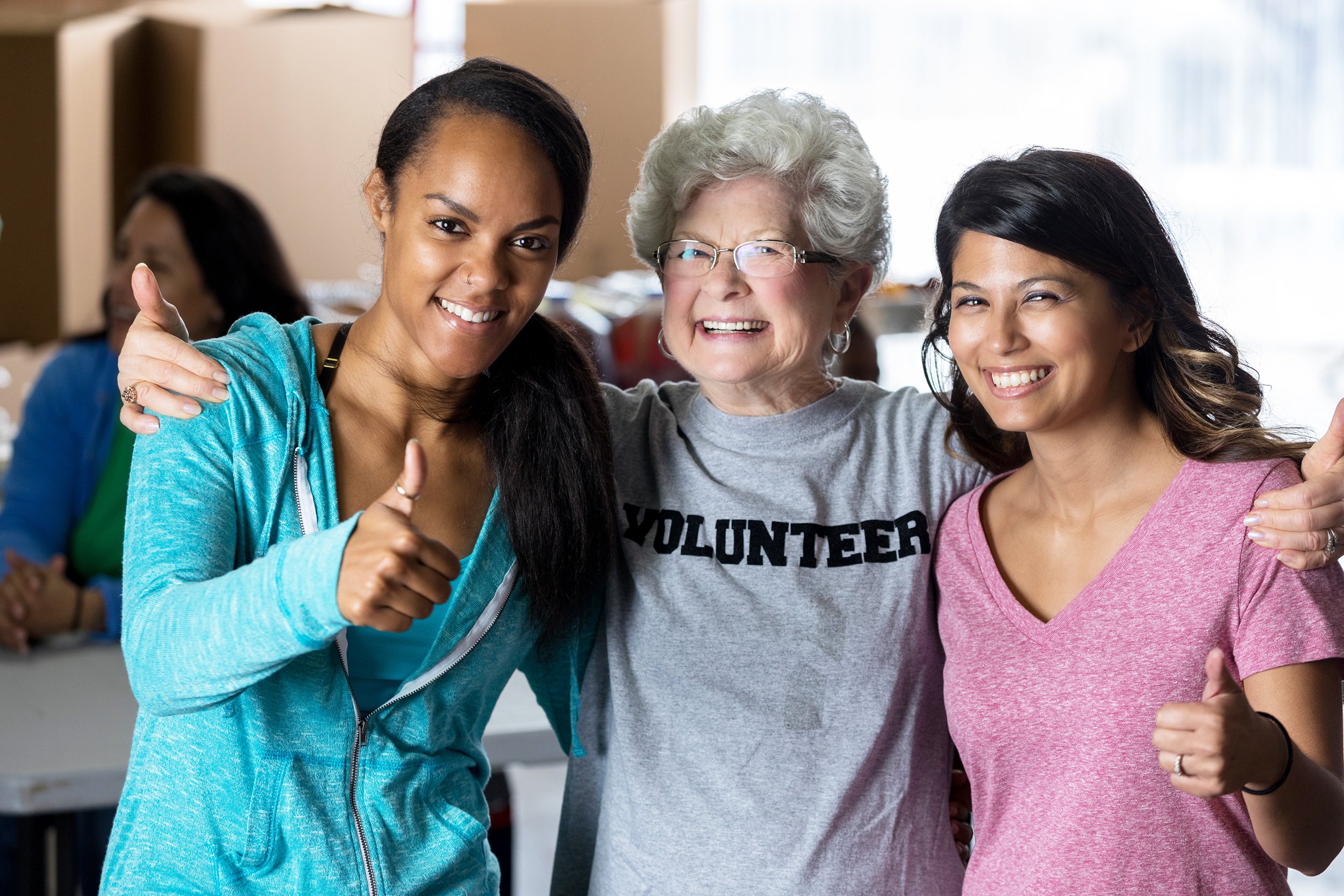 Group of woman of different ages standing and hugging each other's side