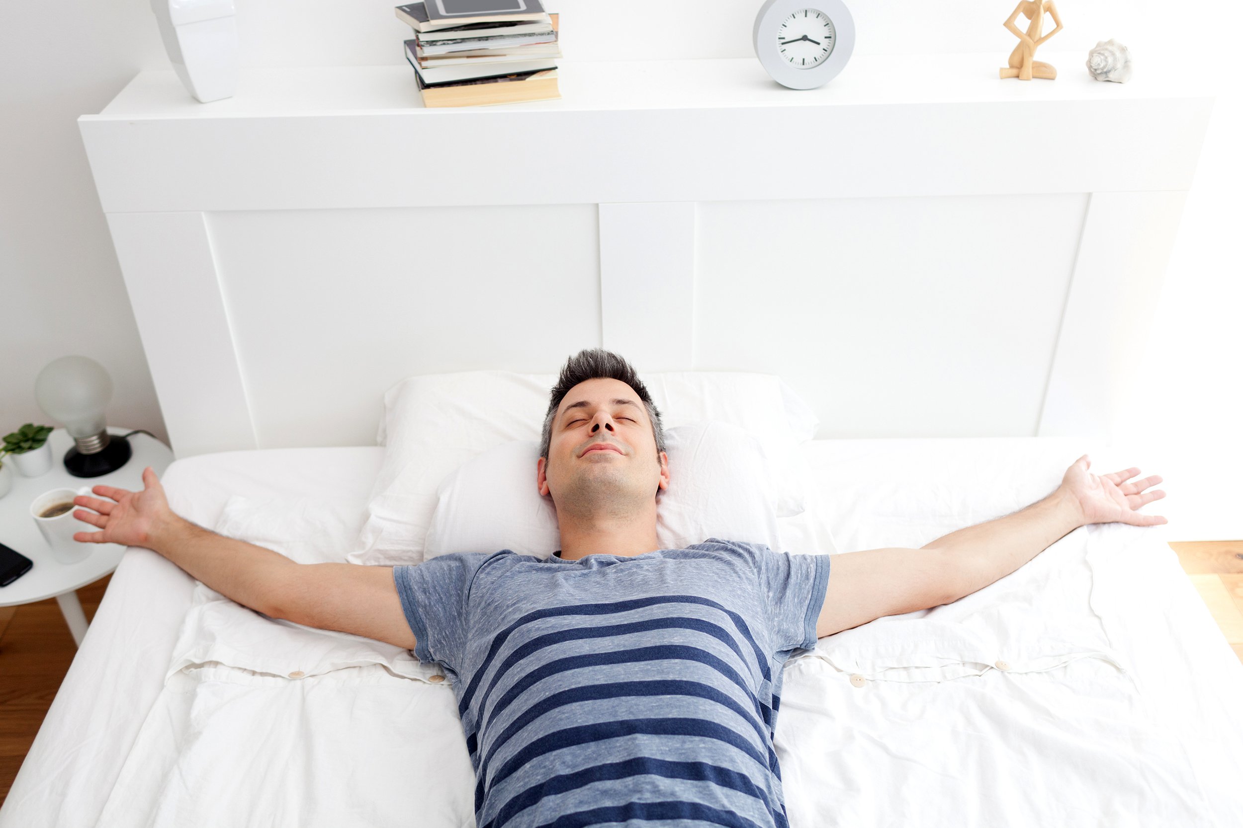 Man relaxed and spread out on bed