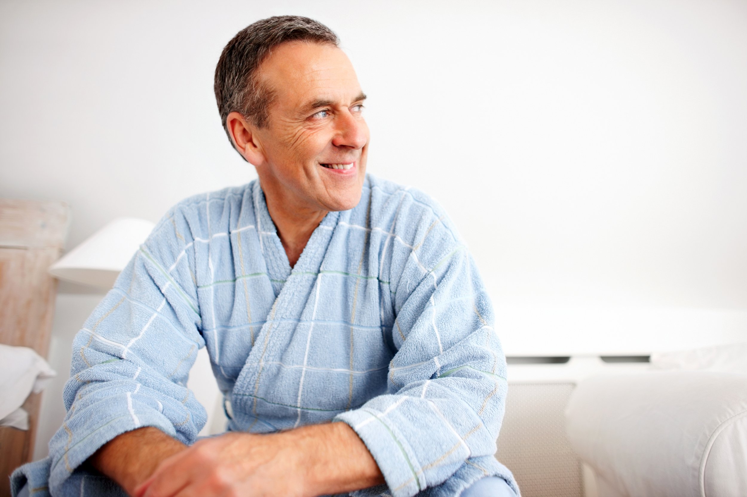 Senior man smiling wearing a blue robe