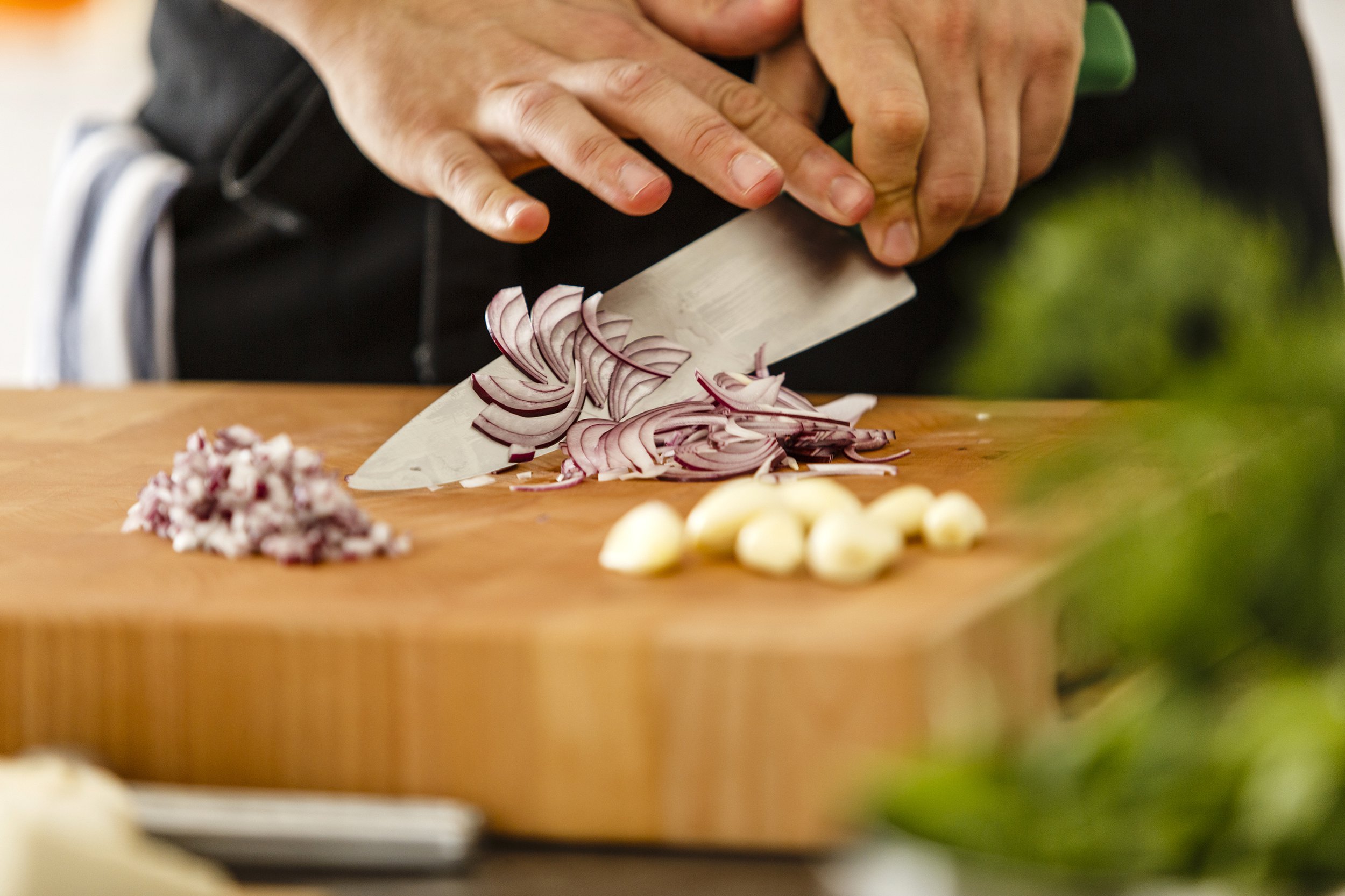 Knife chopping red onions