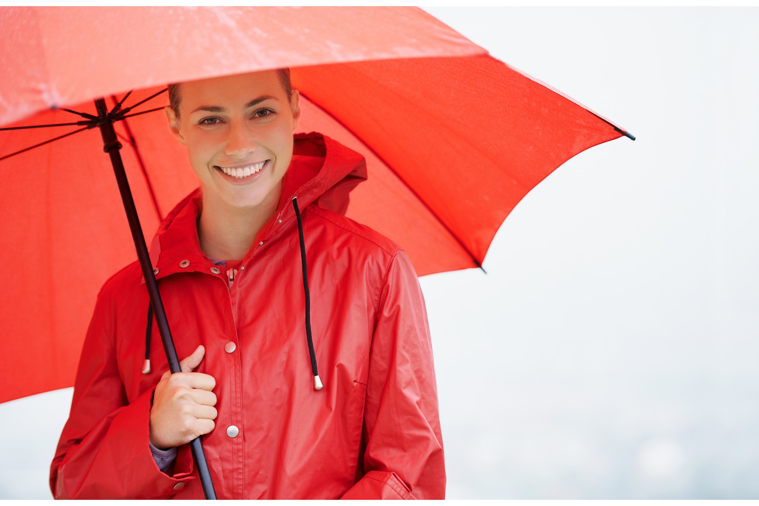 Smiling woman holding a red umbrella