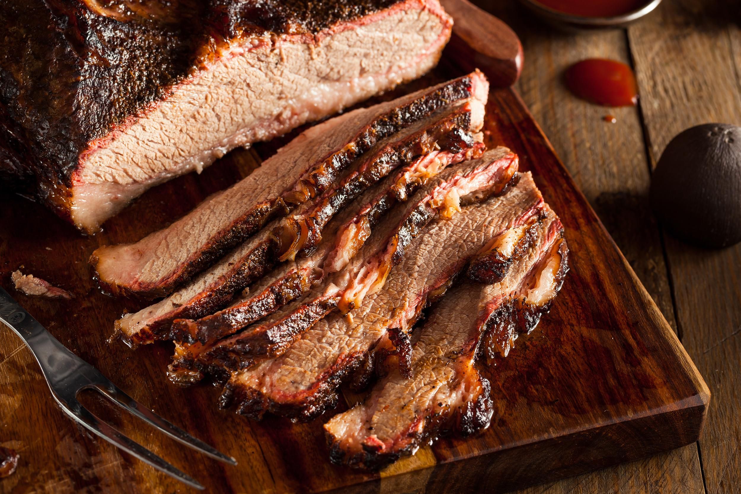 Braised Brisket cut into slices on a wood cutting board