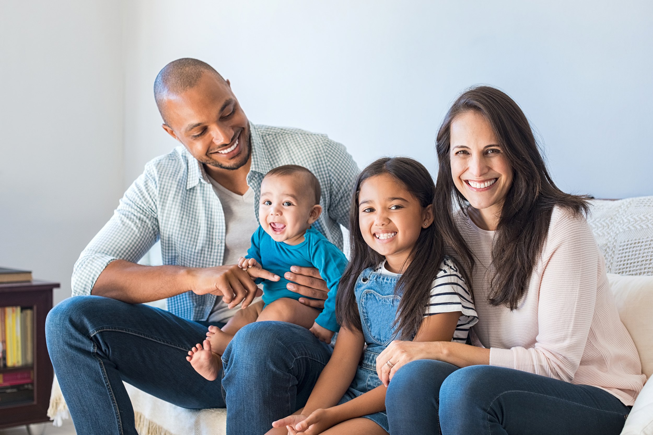 Family sitting on couch about to pose for a photo