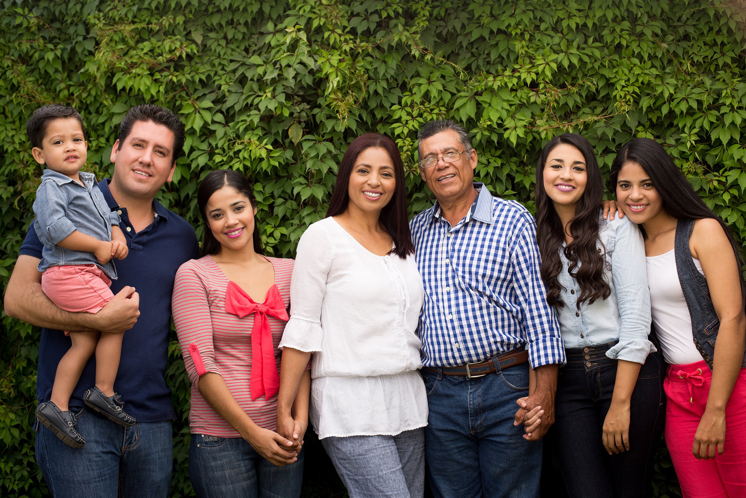 Large family posing for a portrait wearing a similar color scheme