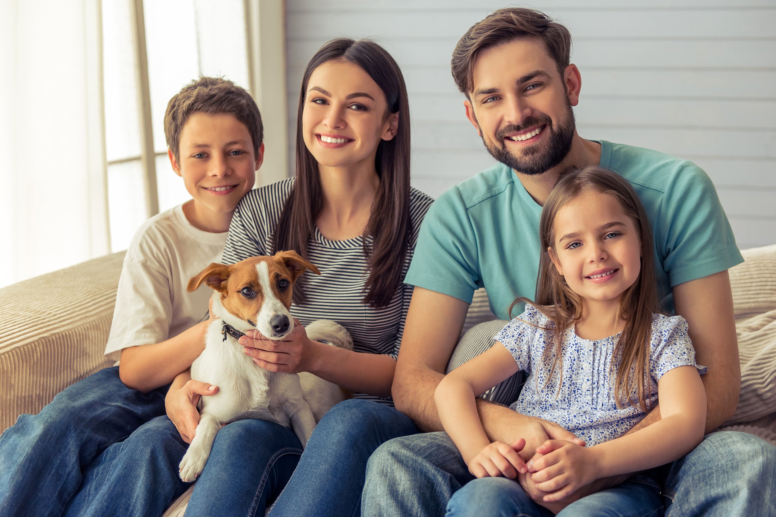 Family taking a photo inside their house sitting next to a window with good lighting