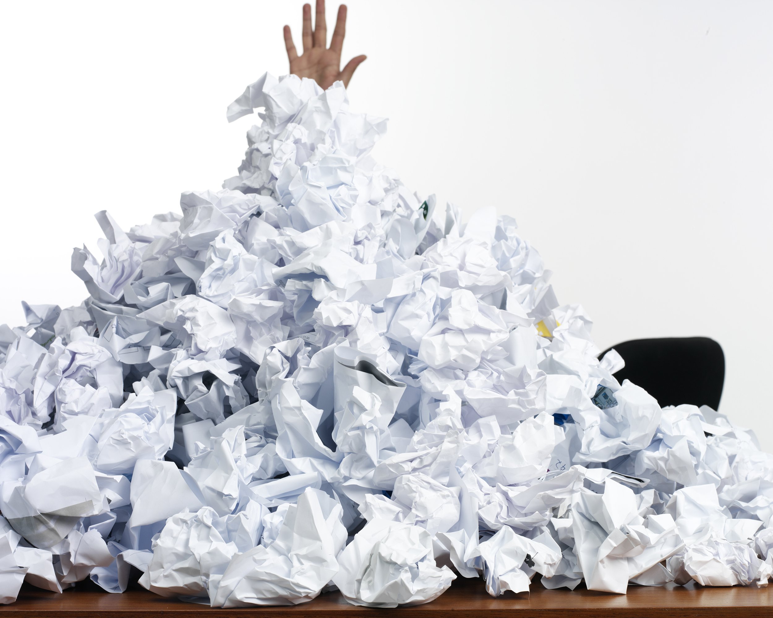 person overtaken by paper clutter