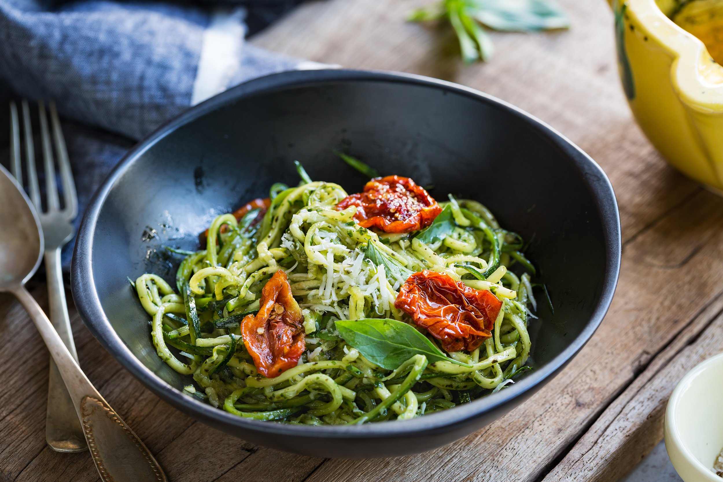 zucchini pasta in pesto sauce with sun dried tomato