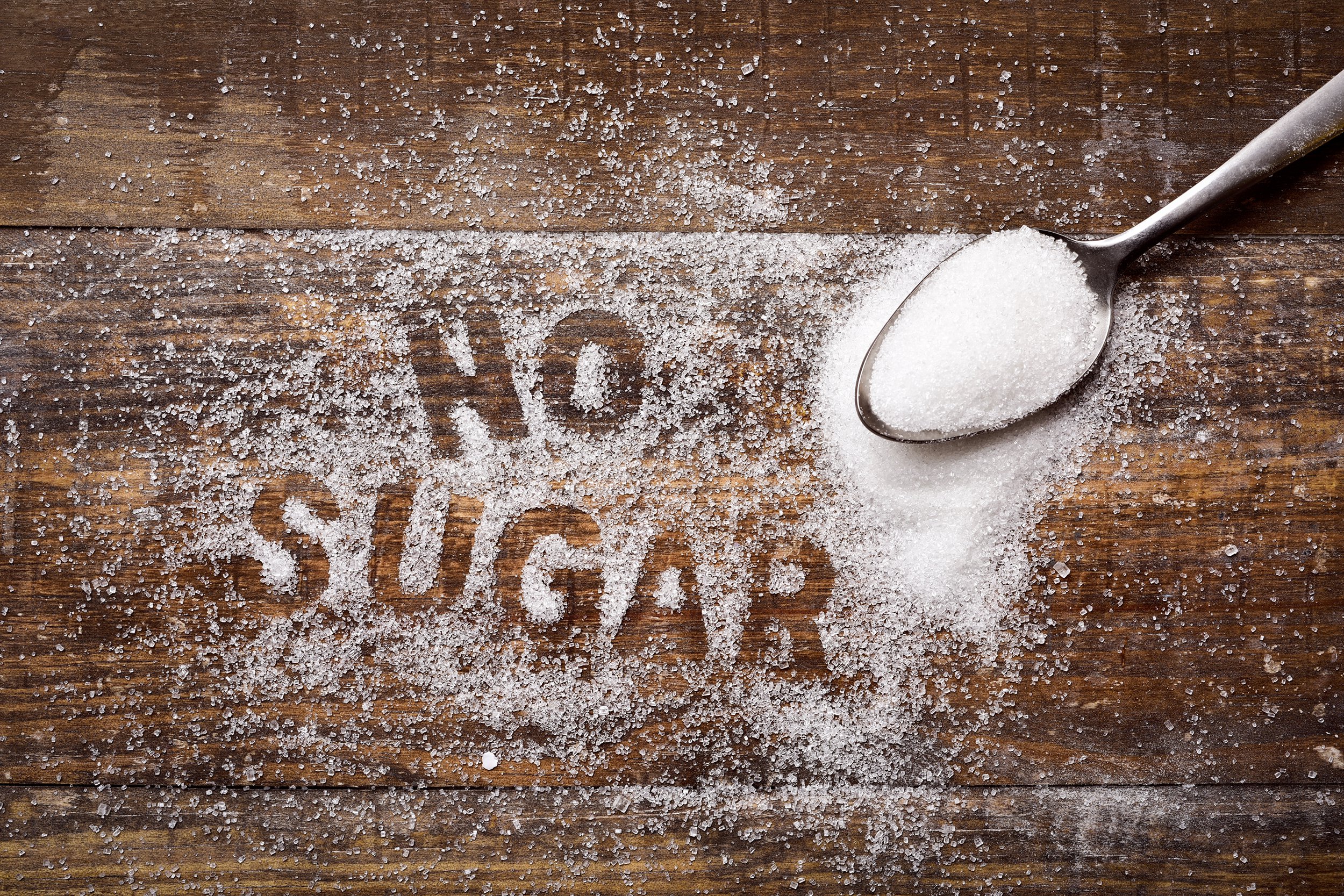 text no sugar written with sugar on wooden board