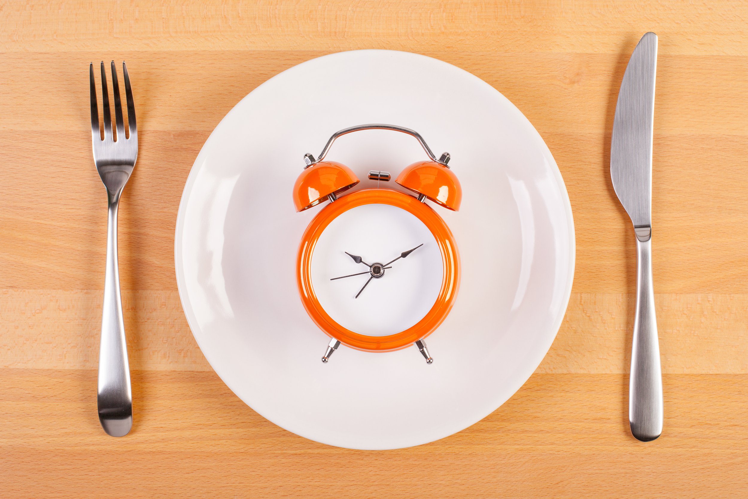 clock on plate with fork and knife