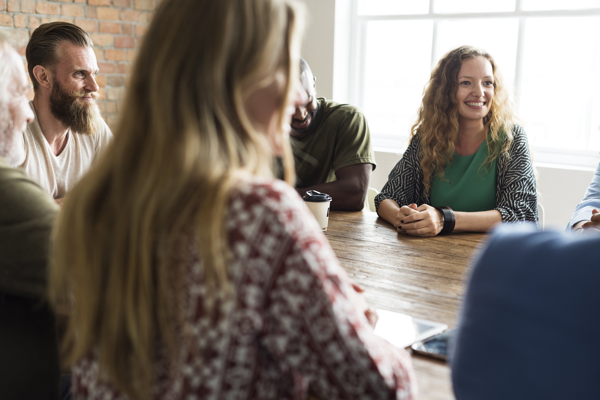 group of people sitting at table having a meeting