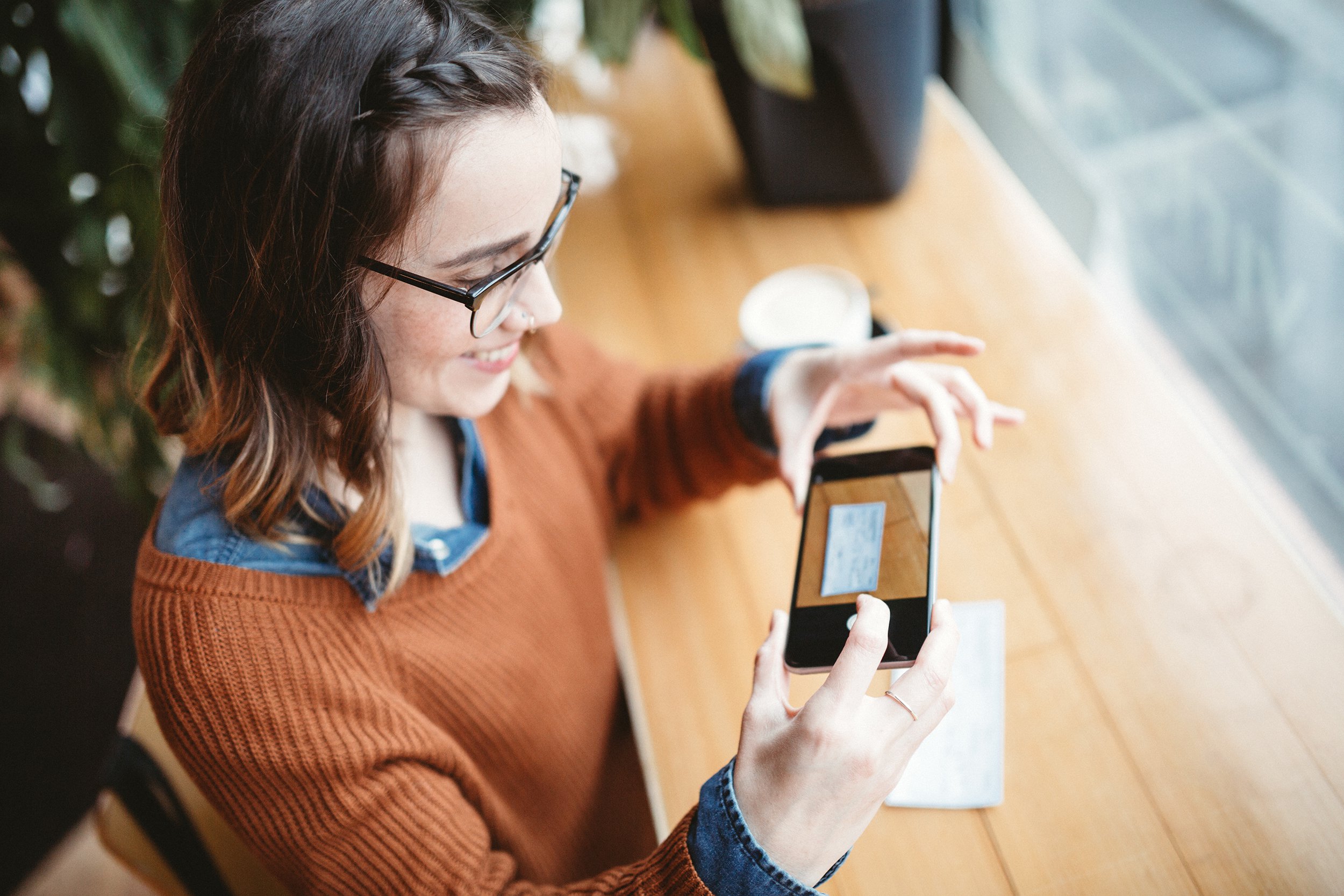 woman making check remote deposit capture at cafe