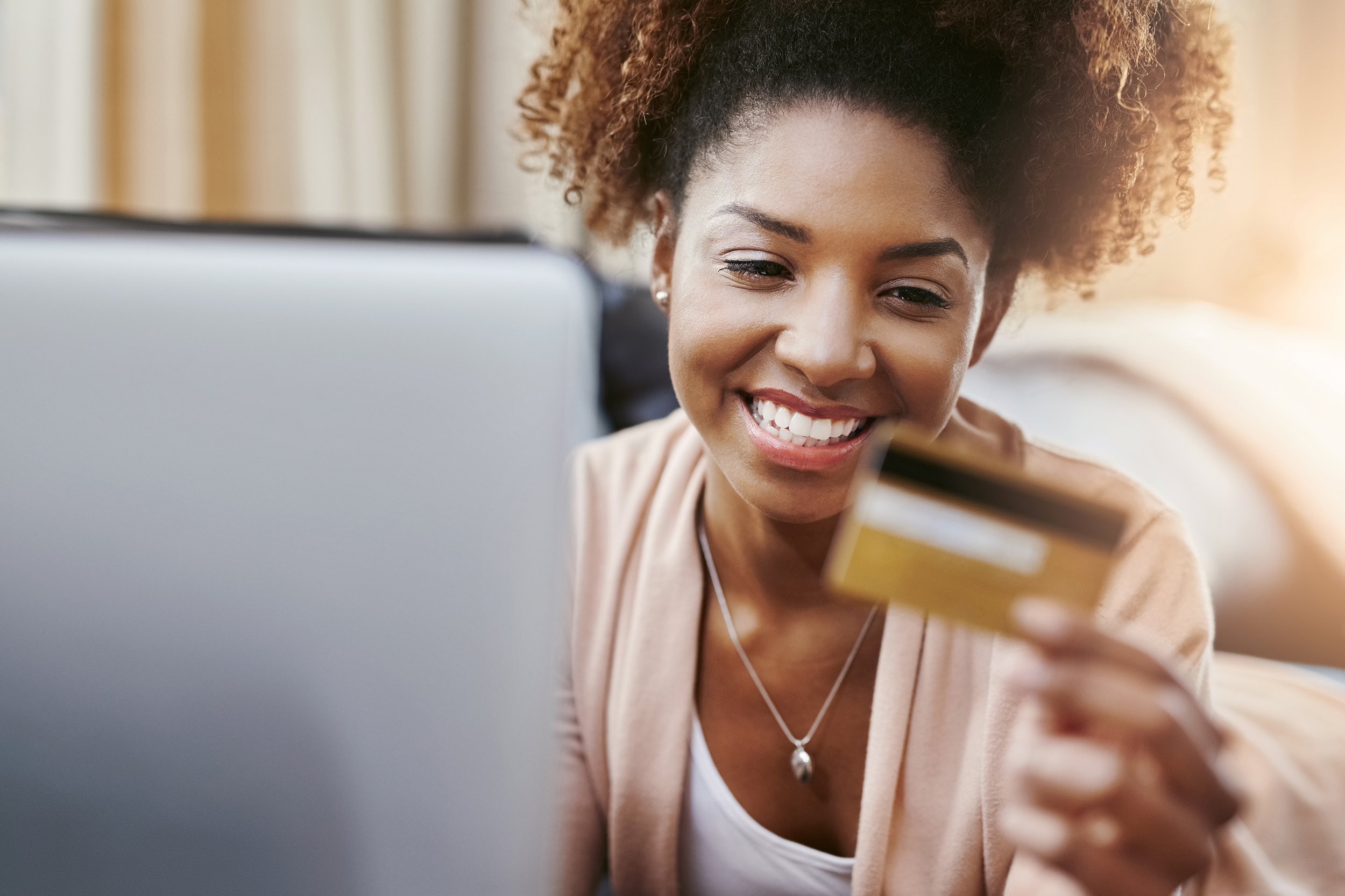 African American holding credit card while shopping on laptop