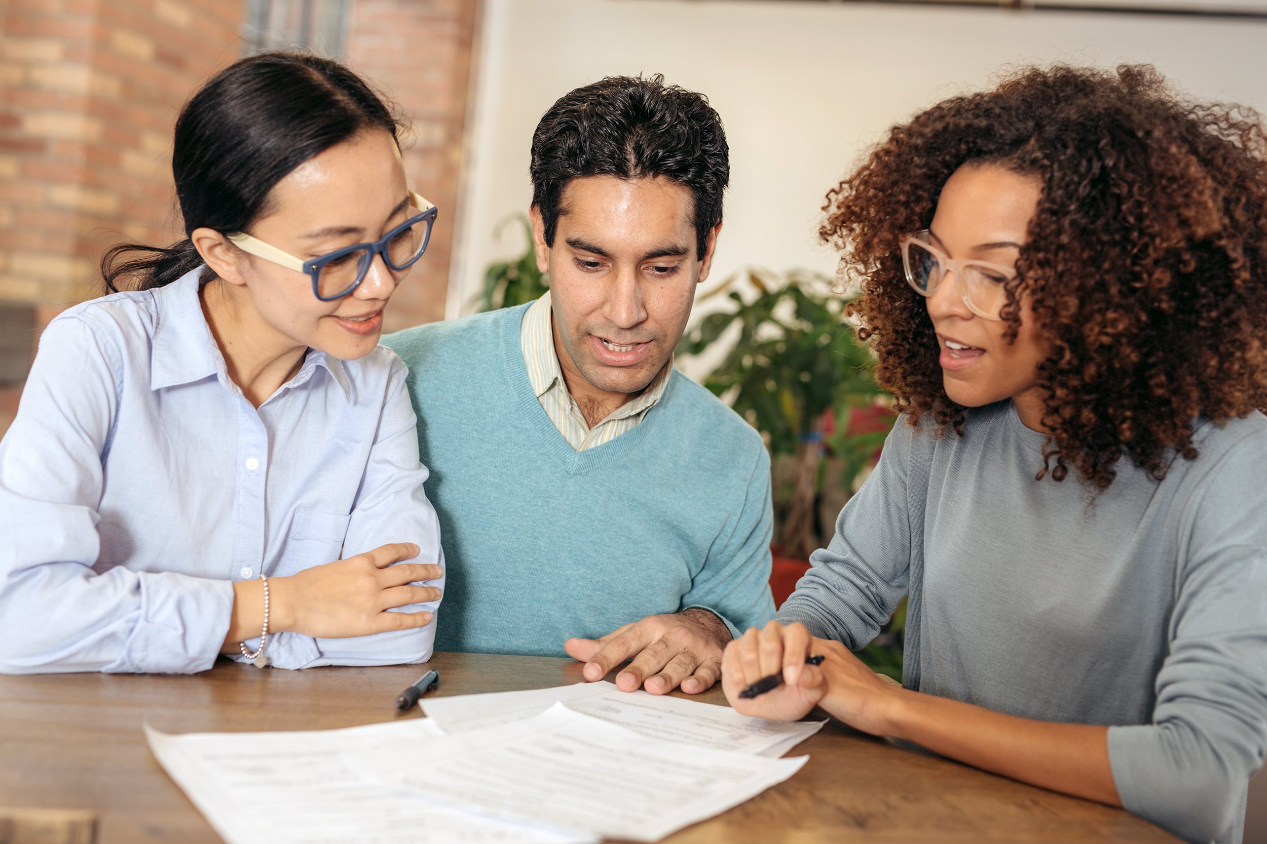 couple getting help with bank worker, sitting at desk