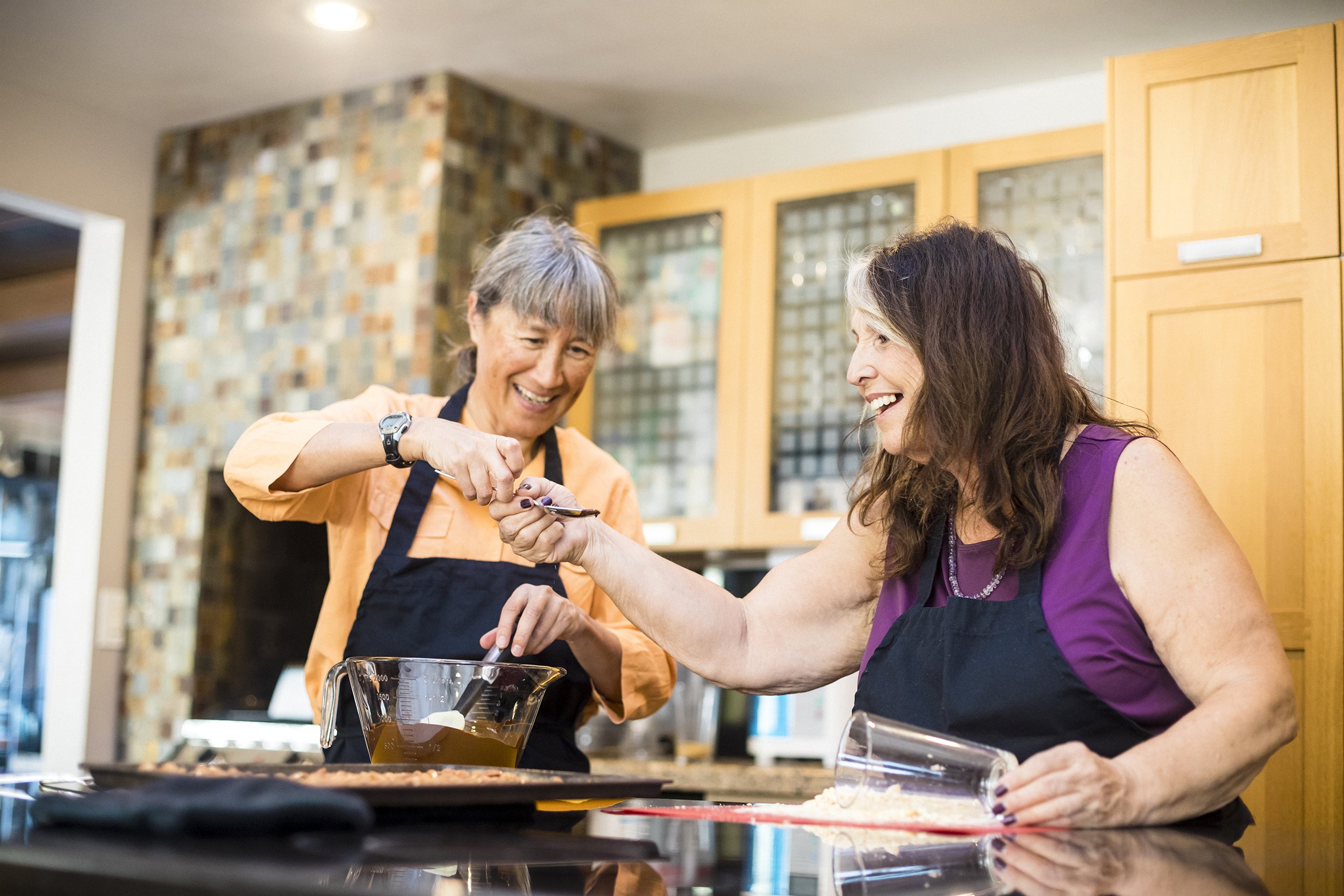 senior women friends cooking chocolate in kitchen
